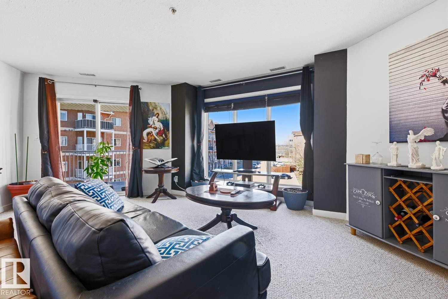 Living area featuring light-colored carpeting and white walls with contrasting dark accent walls - 304 4312 139 Ave, Edmonton, AB - Indoor