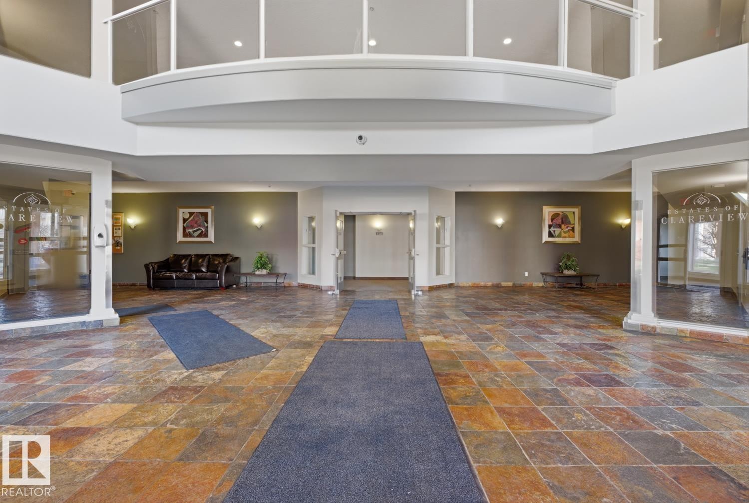 Two-story foyer featuring multi-toned tile flooring, recessed lighting, and a second-story balcony with a glass railing - 304 4312 139 Ave, Edmonton, AB - Indoor Photo Showing Other Room