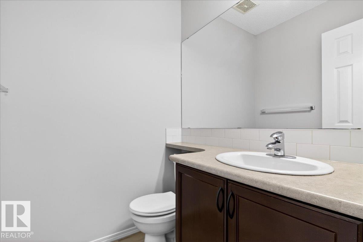 Vanity with an integrated oval sink, chrome faucet, and dark wood-finish cabinetry - #7 18004 89 St Nw, Edmonton, AB - Indoor Photo Showing Bathroom