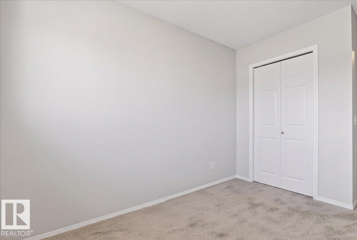 Neutral tone walls with white trim - #7 18004 89 St Nw, Edmonton, AB - Indoor Photo Showing Other Room