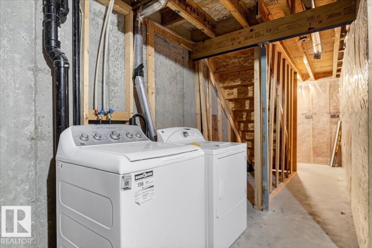 Unfinished basement area featuring a concrete foundation, exposed wood framing, and utility hookups - #7 18004 89 St Nw, Edmonton, AB - Indoor Photo Showing Laundry Room