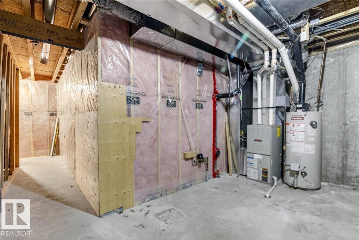 Unfinished basement space with exposed concrete flooring, framed and insulated walls, and visible utility systems - #7 18004 89 St Nw, Edmonton, AB - Indoor Photo Showing Basement