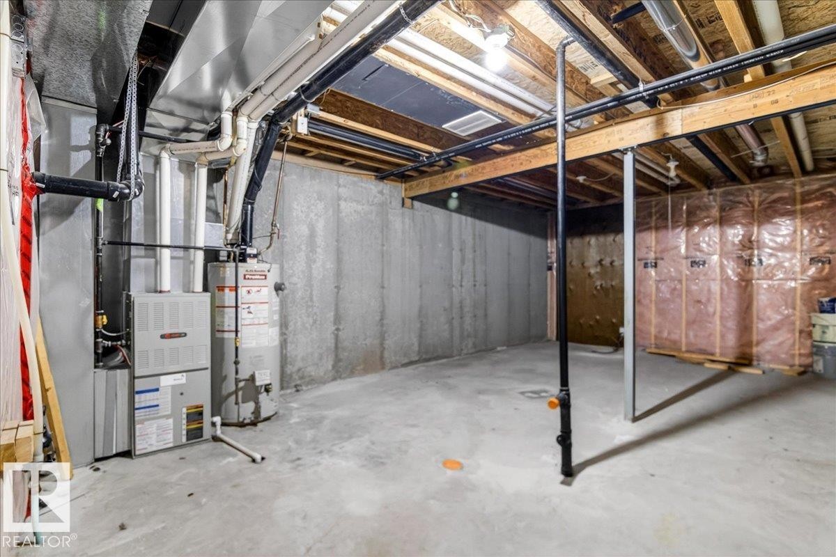 Unfinished basement featuring concrete walls and flooring, exposed ceiling joists, an HVAC system, and a water heater - #7 18004 89 St Nw, Edmonton, AB - Indoor Photo Showing Basement