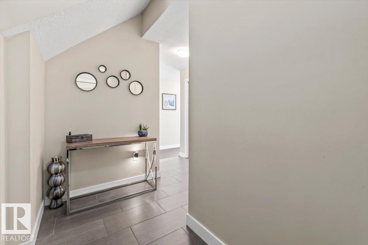 Double-height windows with dark framing and a glass door providing access to an outdoor area - 513 1230 Windermere Way, Edmonton, AB