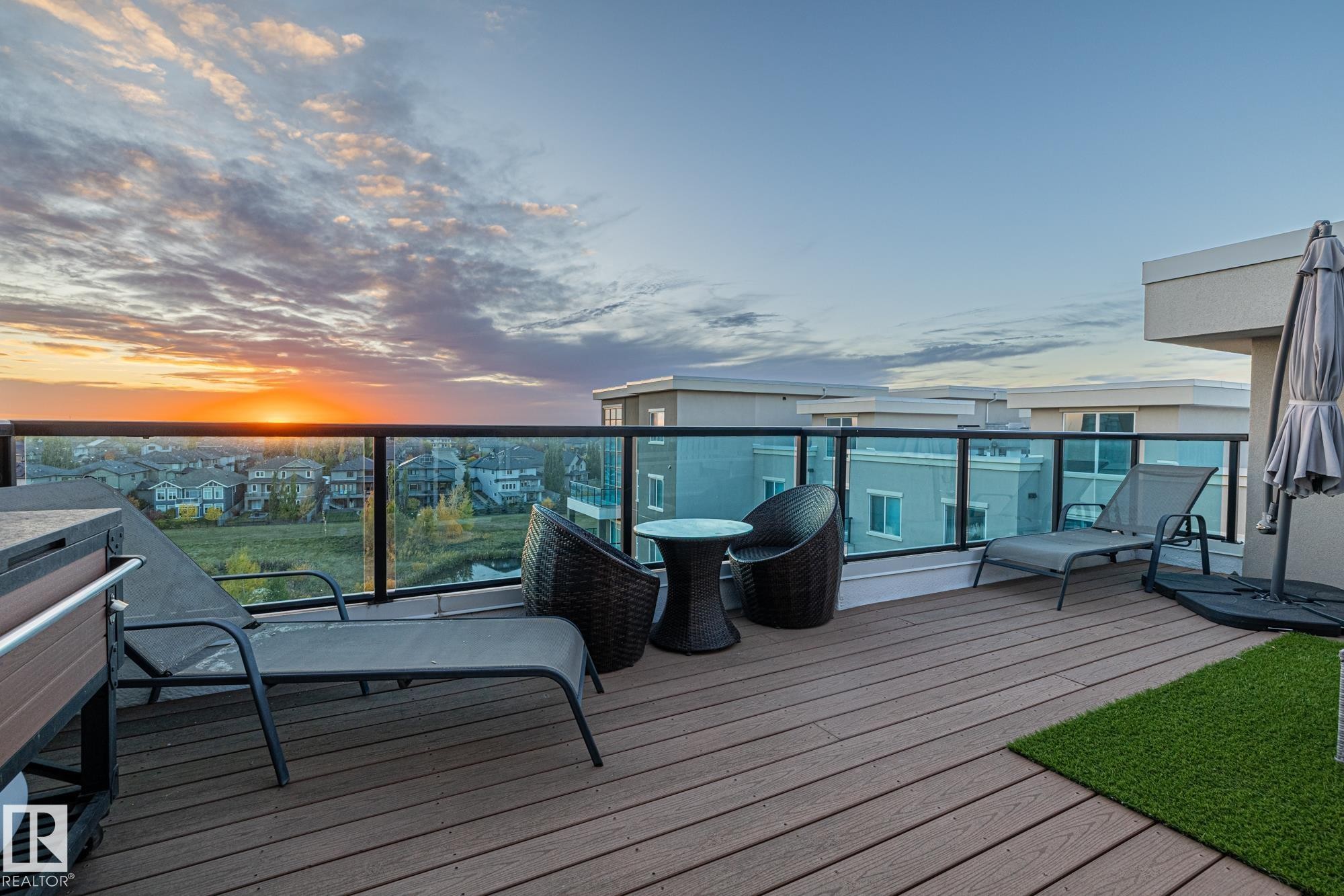 Multi-story condominium building featuring a contemporary design with multi-tone exterior siding, expansive glass windows, and private balconies with clear glass railings - 513 1230 Windermere Way, Edmonton, AB