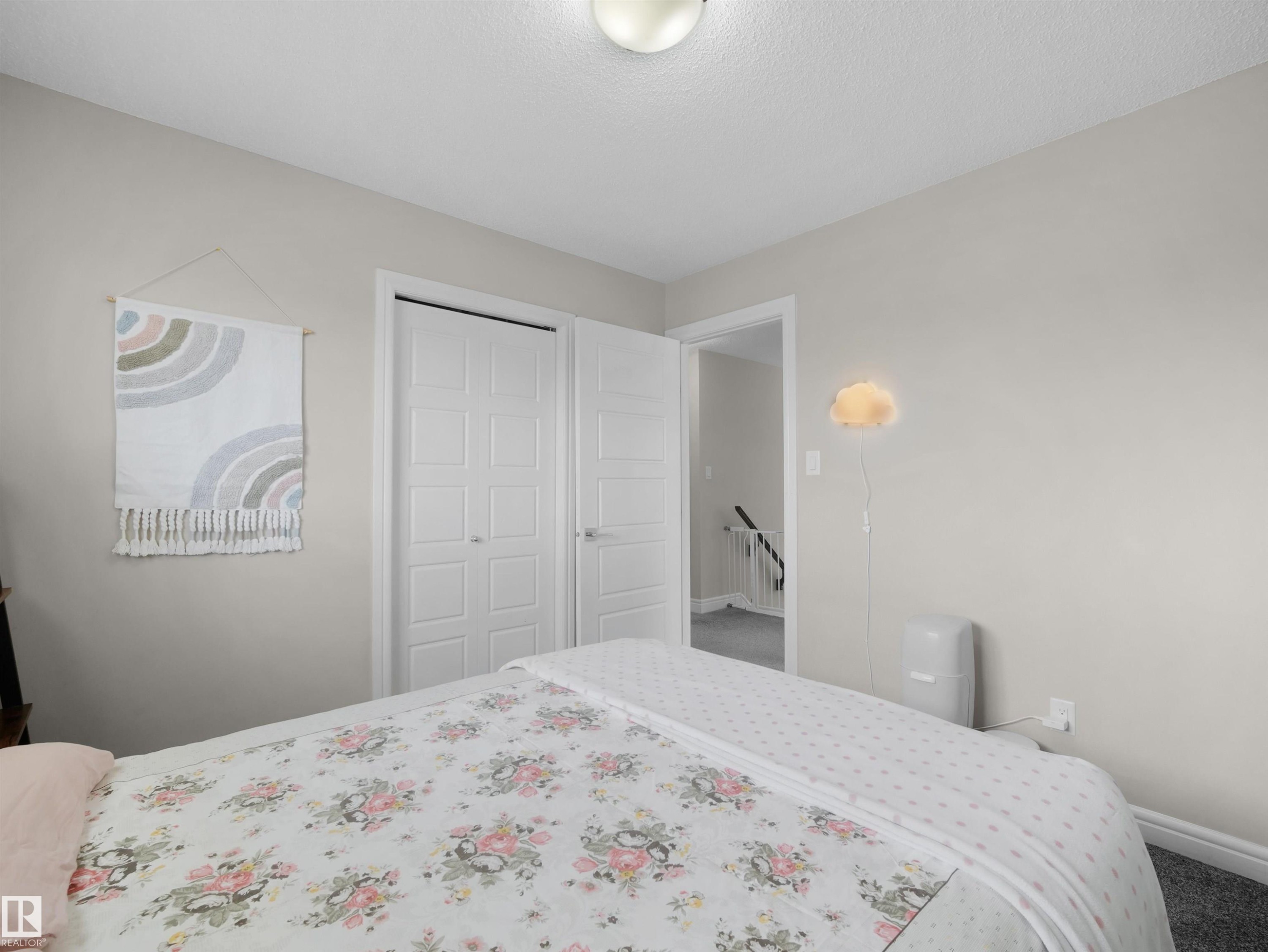 Bedroom featuring neutral wall paint, textured carpeting, and a flush-mount ceiling light fixture - 3247 15 Avenue Nw, Edmonton, AB