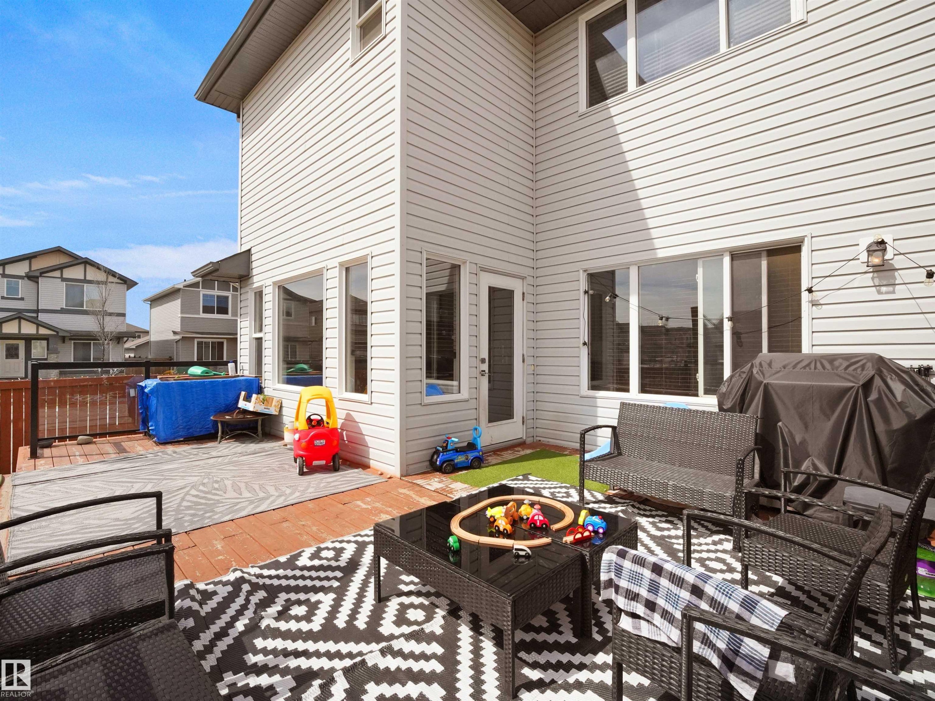 Multi-level exterior deck featuring wood-finish flooring, a privacy fence, and an outdoor light fixture - 3247 15 Avenue Nw, Edmonton, AB
