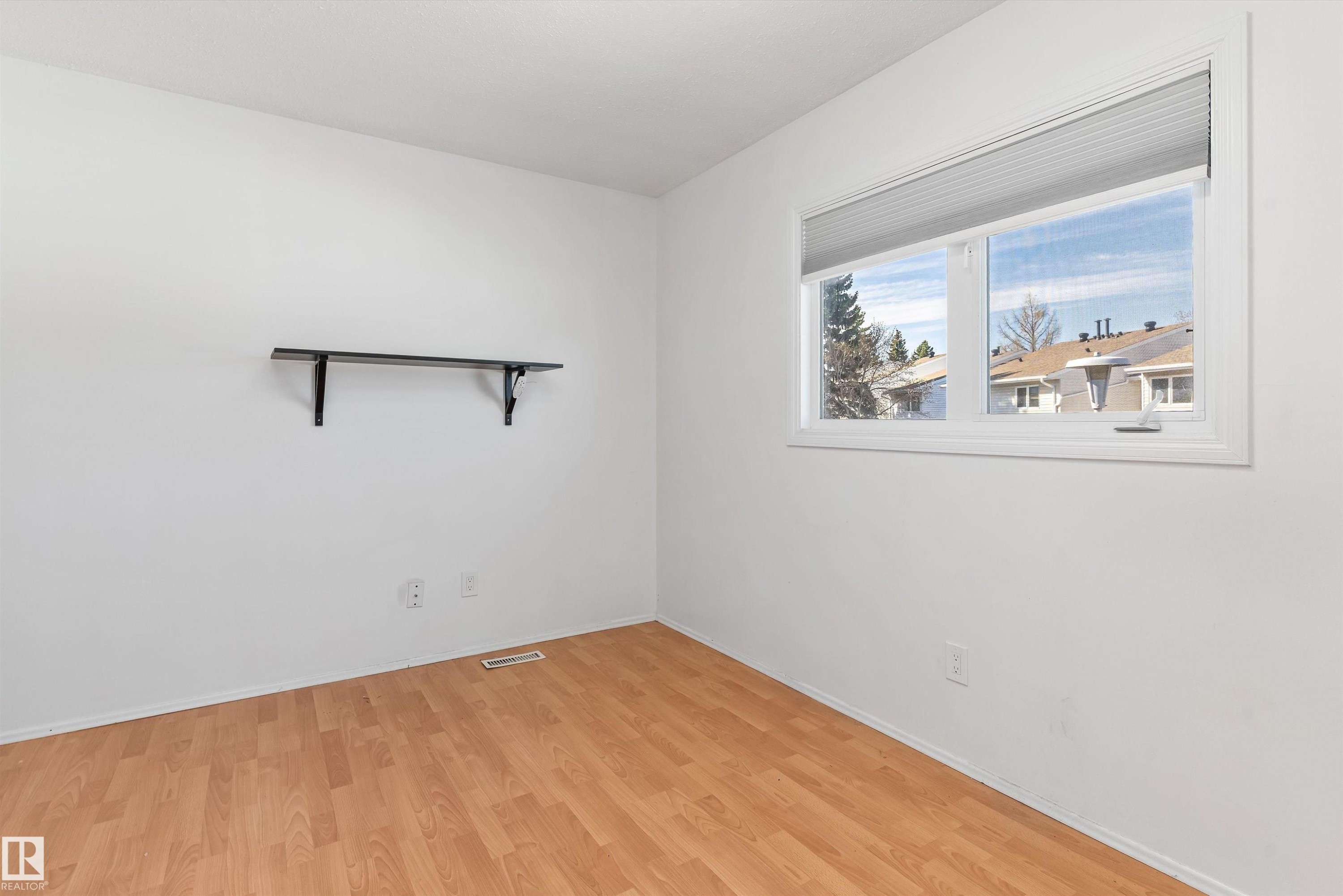 Bright room with wood-finish flooring and a white window frame - 6734 36A Avenue, Edmonton, AB - Indoor Photo Showing Other Room