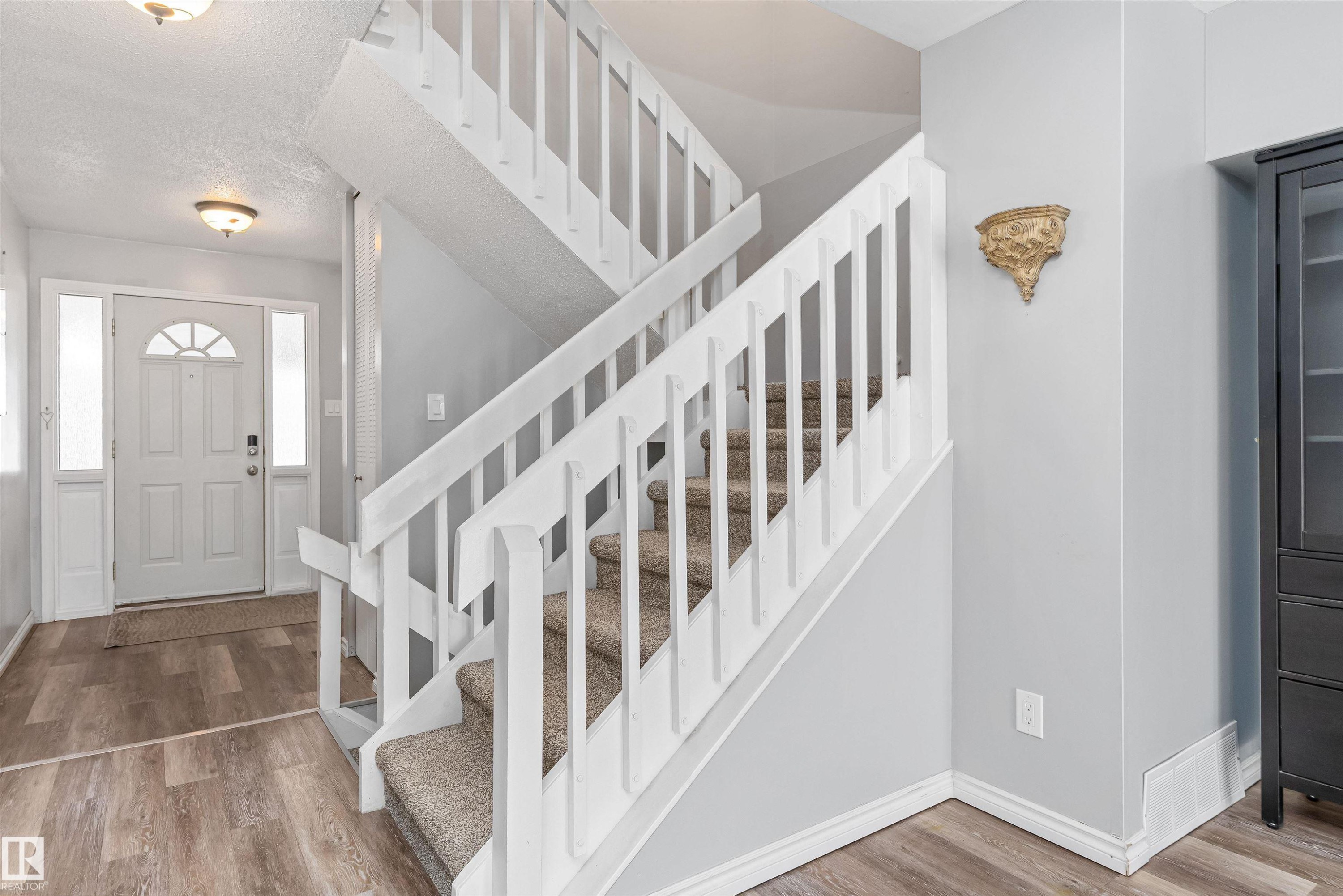 Entryway featuring light wood-finish flooring, a white paneled door with an arched window, and sidelight windows - 6734 36A Avenue, Edmonton, AB - Indoor Photo Showing Other Room