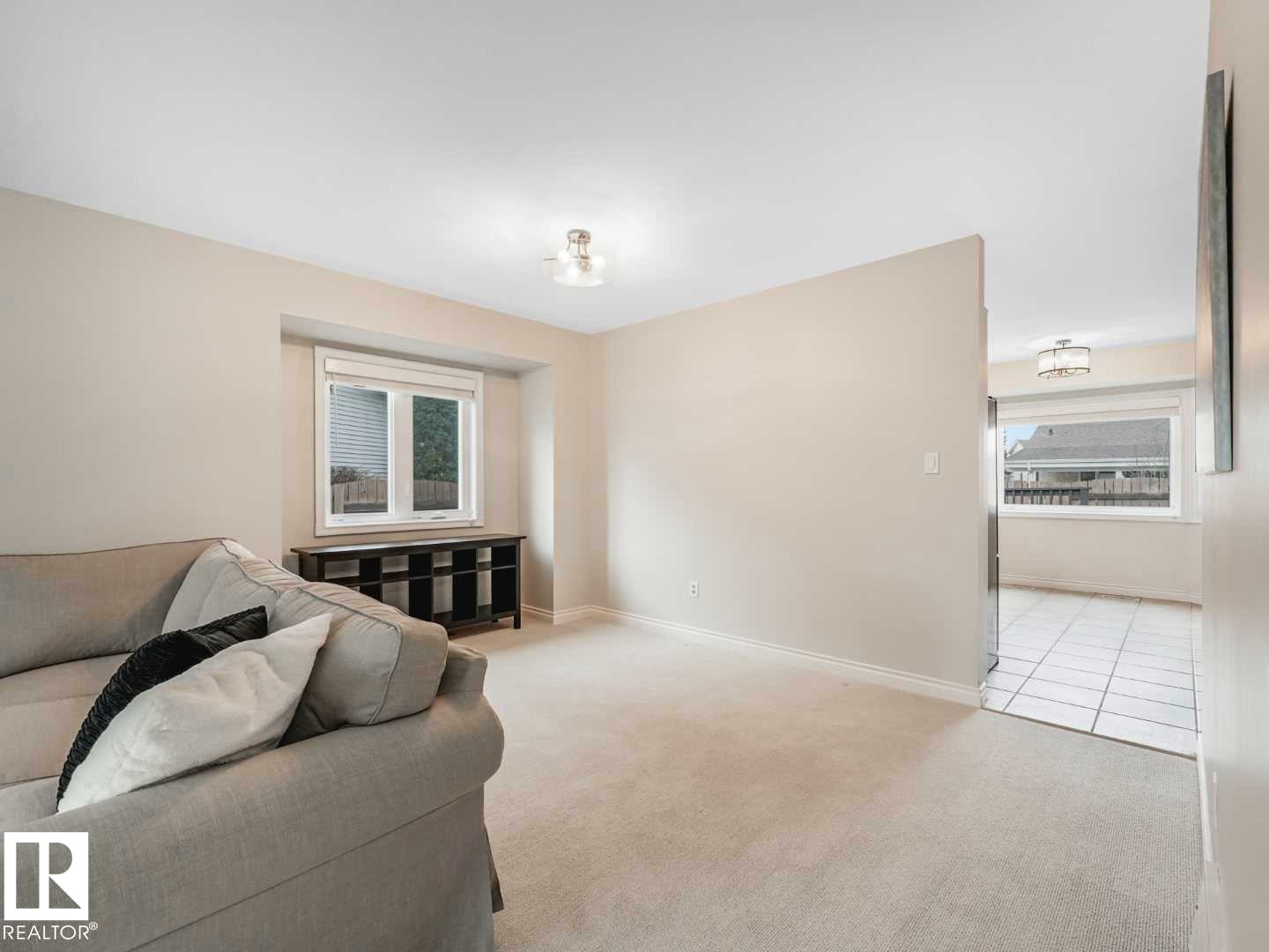 Living area featuring light-toned carpeting and a window with blinds - 4011 104 Street, Edmonton, AB - Indoor Photo Showing Other Room