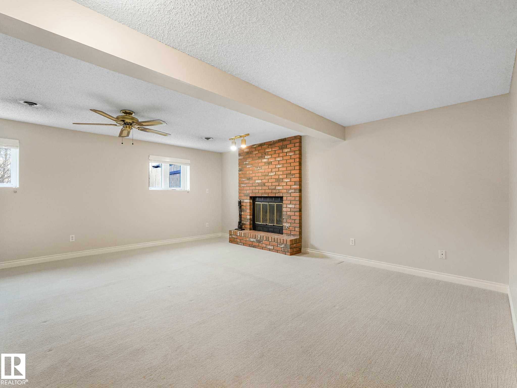 Expansive room featuring light-toned carpeting and neutral wall tones - 4011 104 Street, Edmonton, AB - Indoor With Fireplace