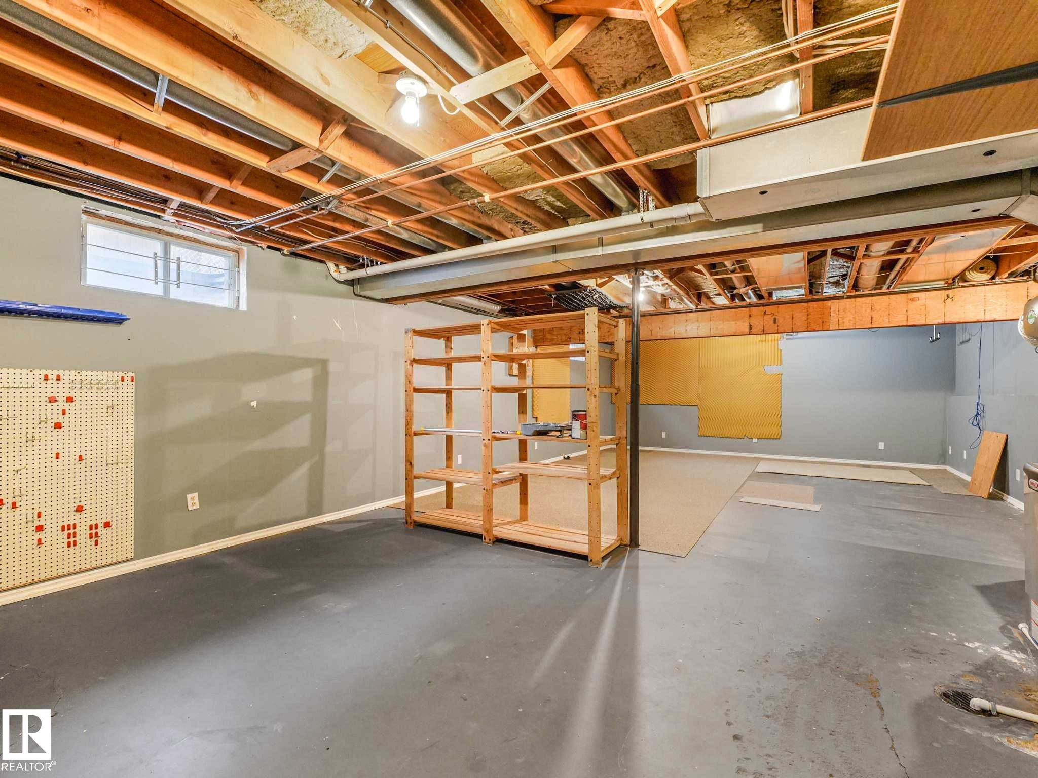 Unfinished basement with exposed ceiling joists and concrete flooring - 4011 104 Street, Edmonton, AB - Indoor Photo Showing Basement