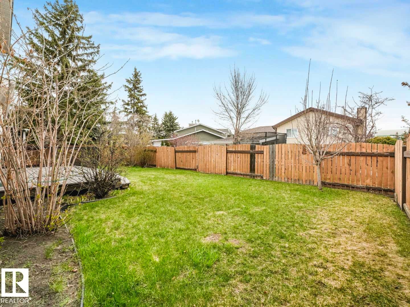 Expansive green lawn with a wood privacy fence - 4011 104 Street, Edmonton, AB - Outdoor