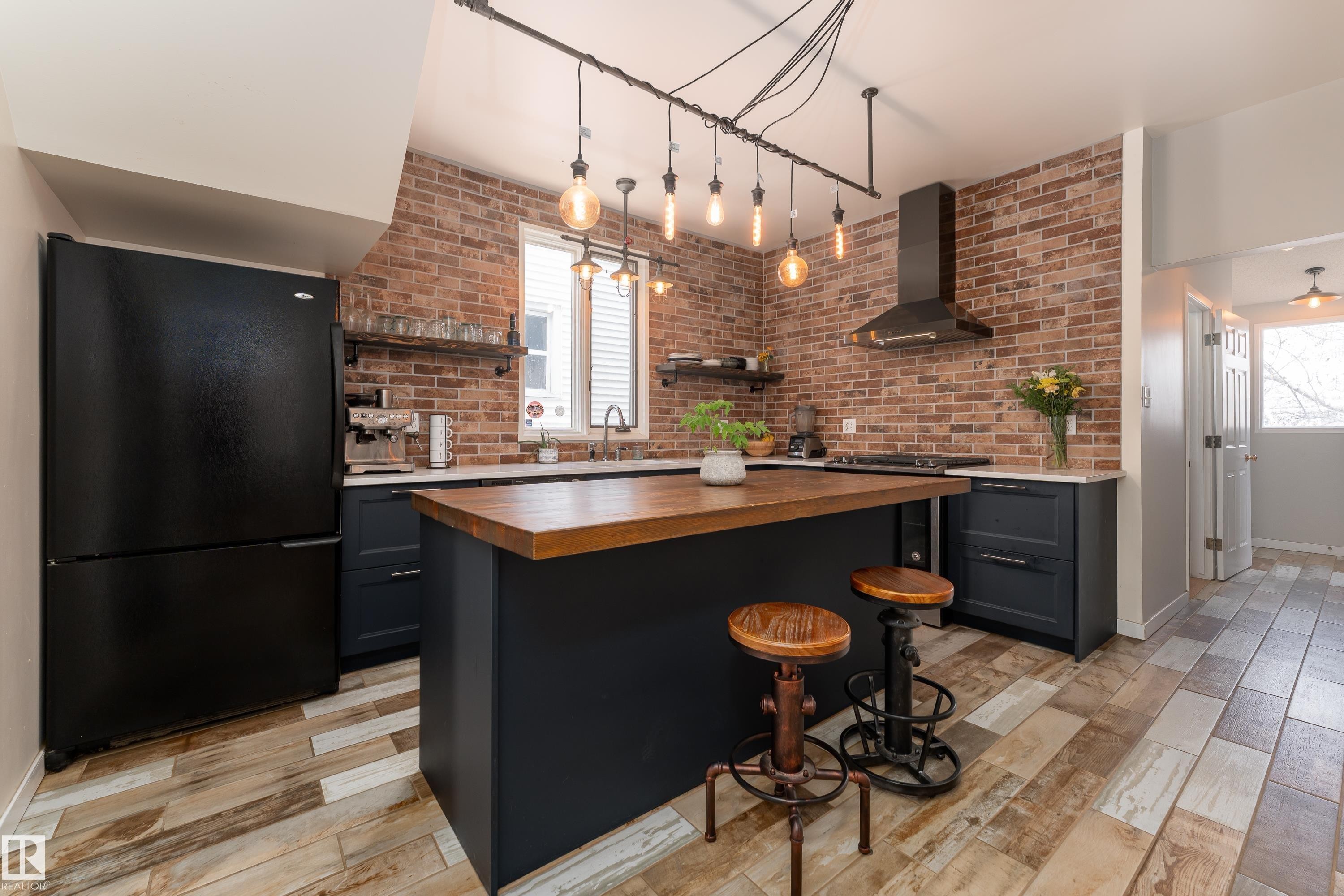 Beautifully updated kitchen with quartz counters, gas stove, and industrial-style lighting - 10956 81 Avenue, Edmonton, AB - Indoor Photo Showing Kitchen