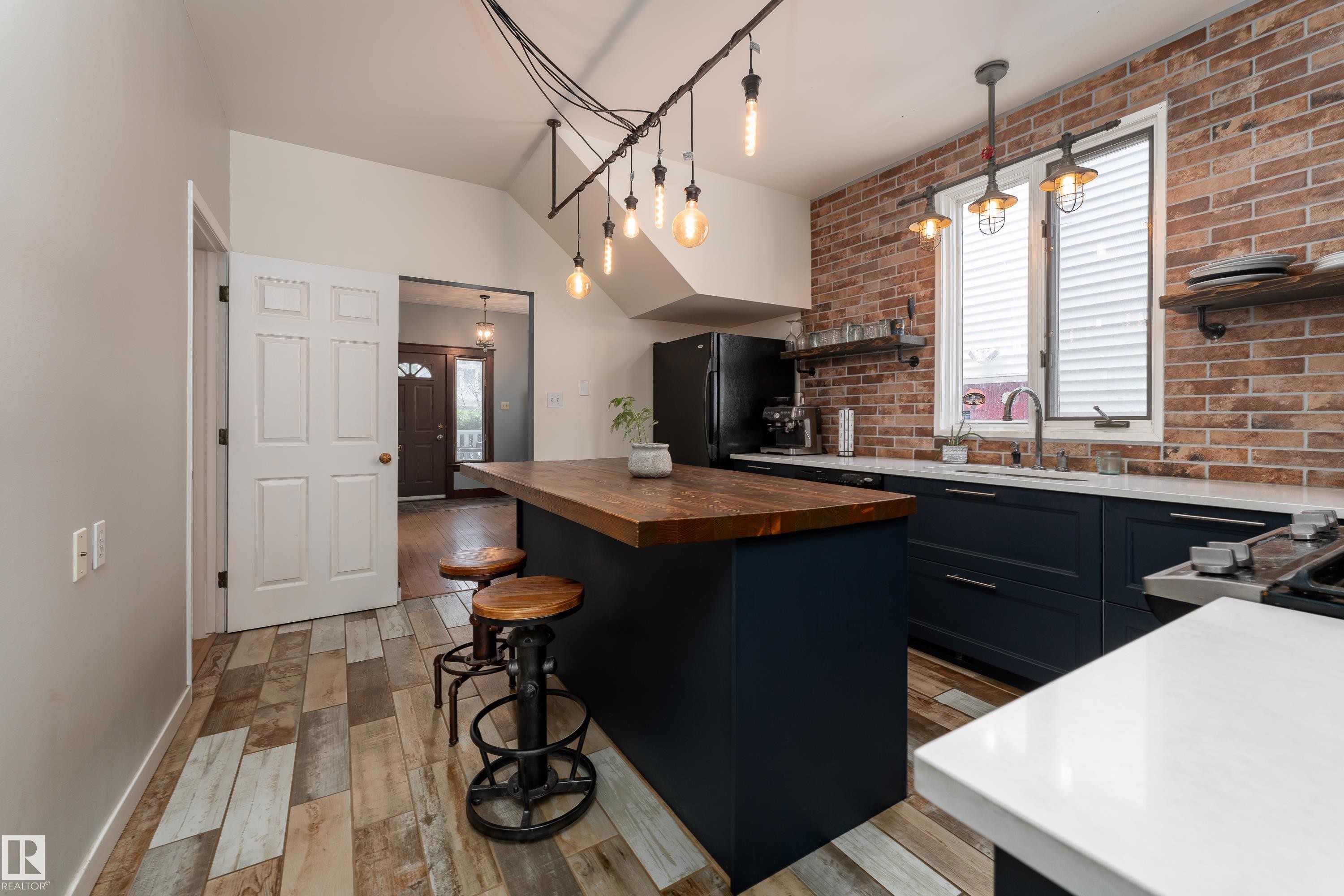 Beautifully updated kitchen with quartz counters, gas stove, and industrial-style lighting - 10956 81 Avenue, Edmonton, AB - Indoor