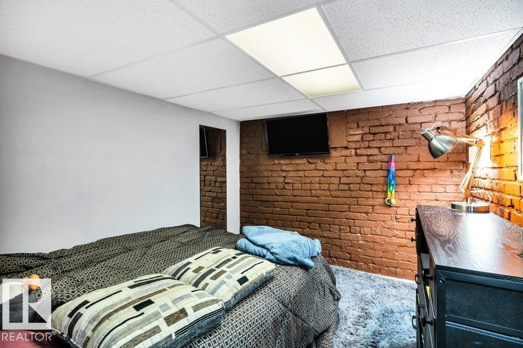 Interior room featuring an exposed brick accent wall - 11445 68 Street, Edmonton, AB - Photo Showing Bedroom