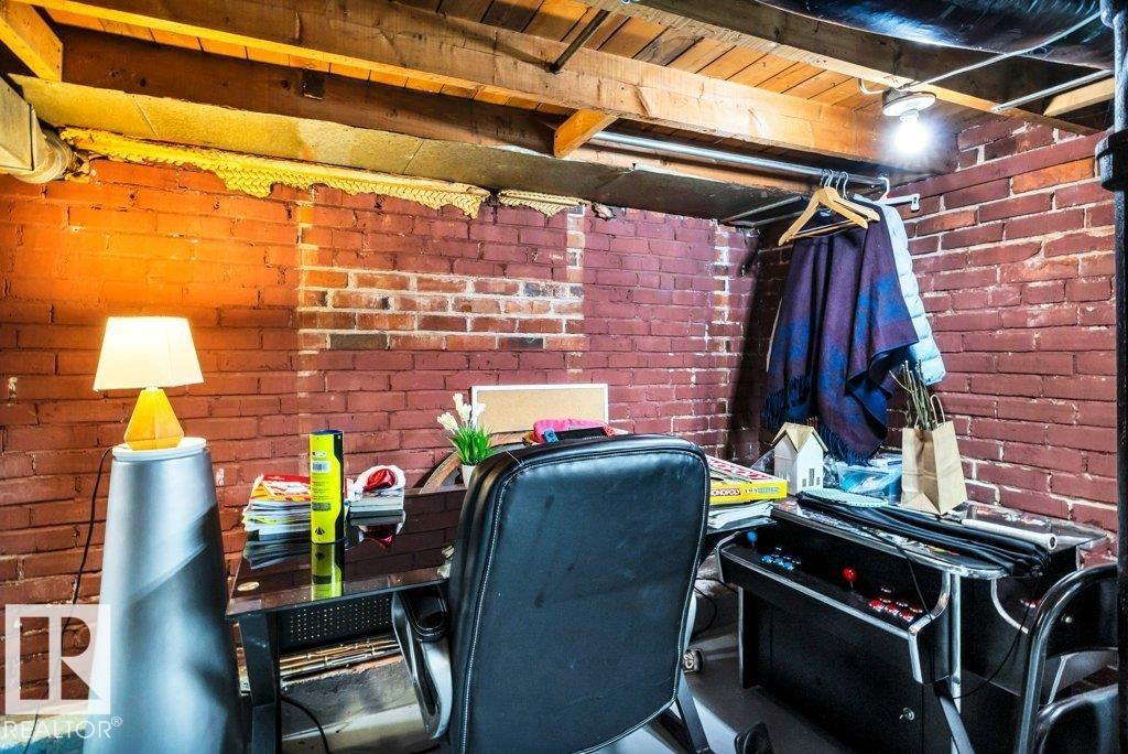Exposed brick walls defining a versatile basement space with wood ceiling joists - 11445 68 Street, Edmonton, AB - Indoor