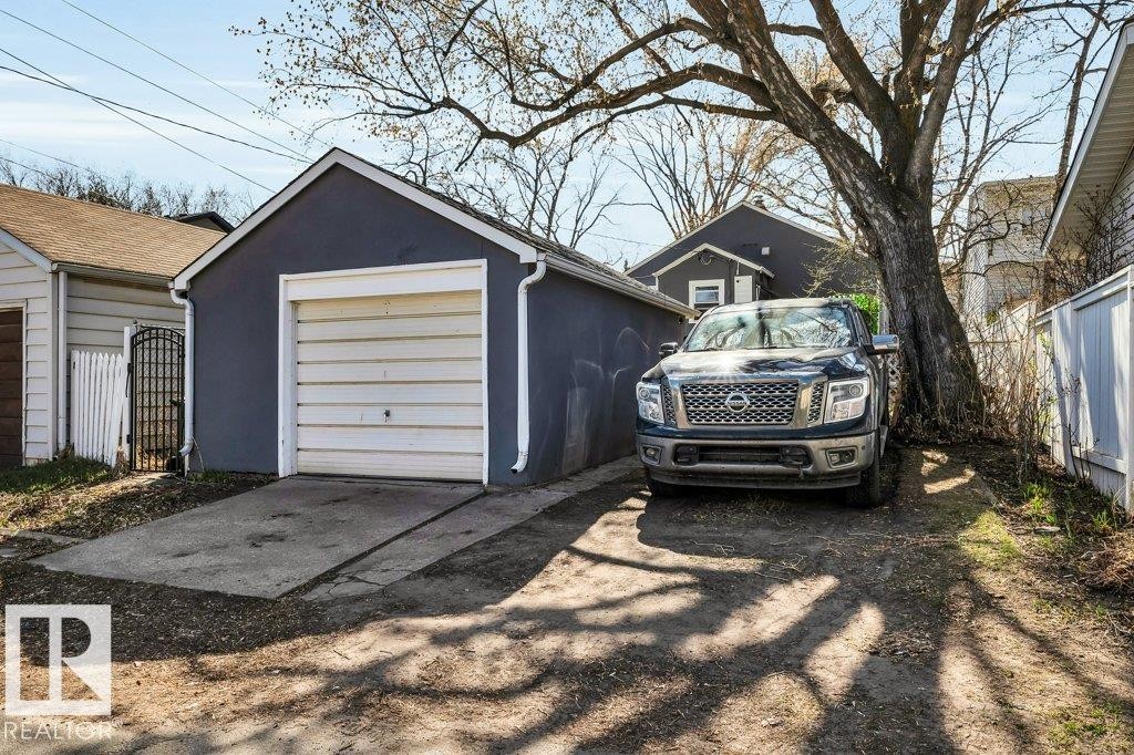 Detached garage featuring a white overhead door and concrete driveway - 11445 68 Street, Edmonton, AB - Outdoor