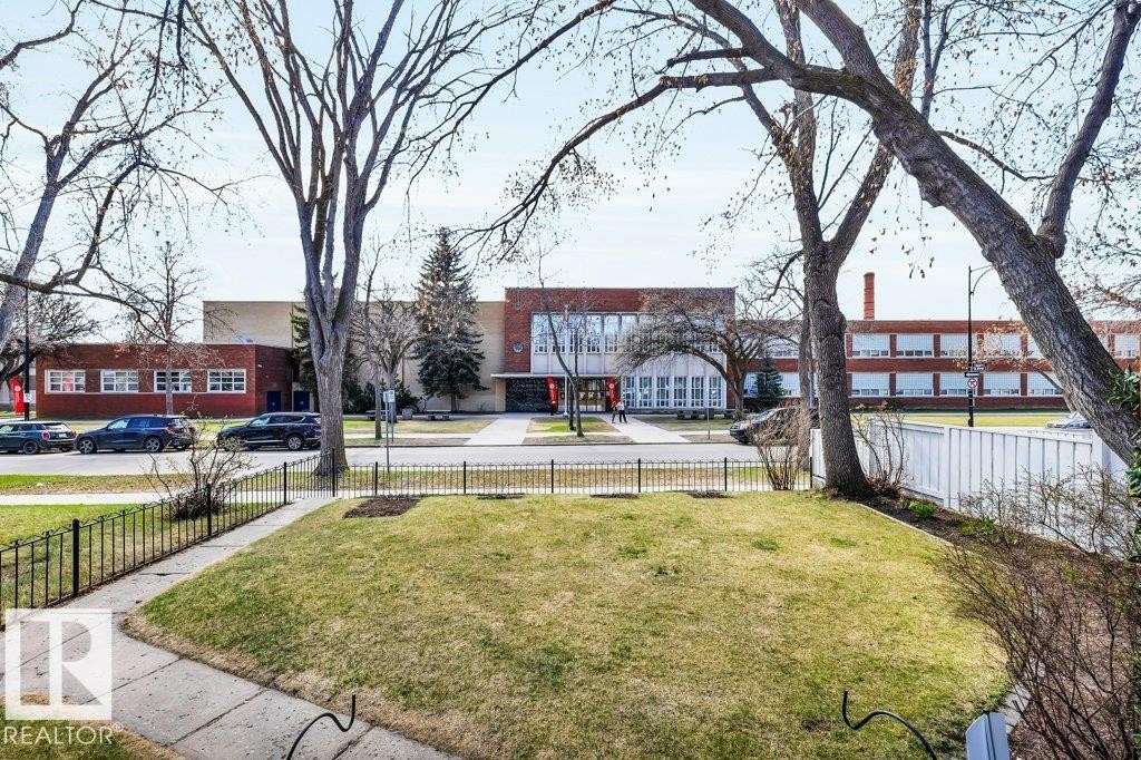 Expansive green lawn and concrete pathway framed by a black metal fence - 11445 68 Street, Edmonton, AB - Outdoor
