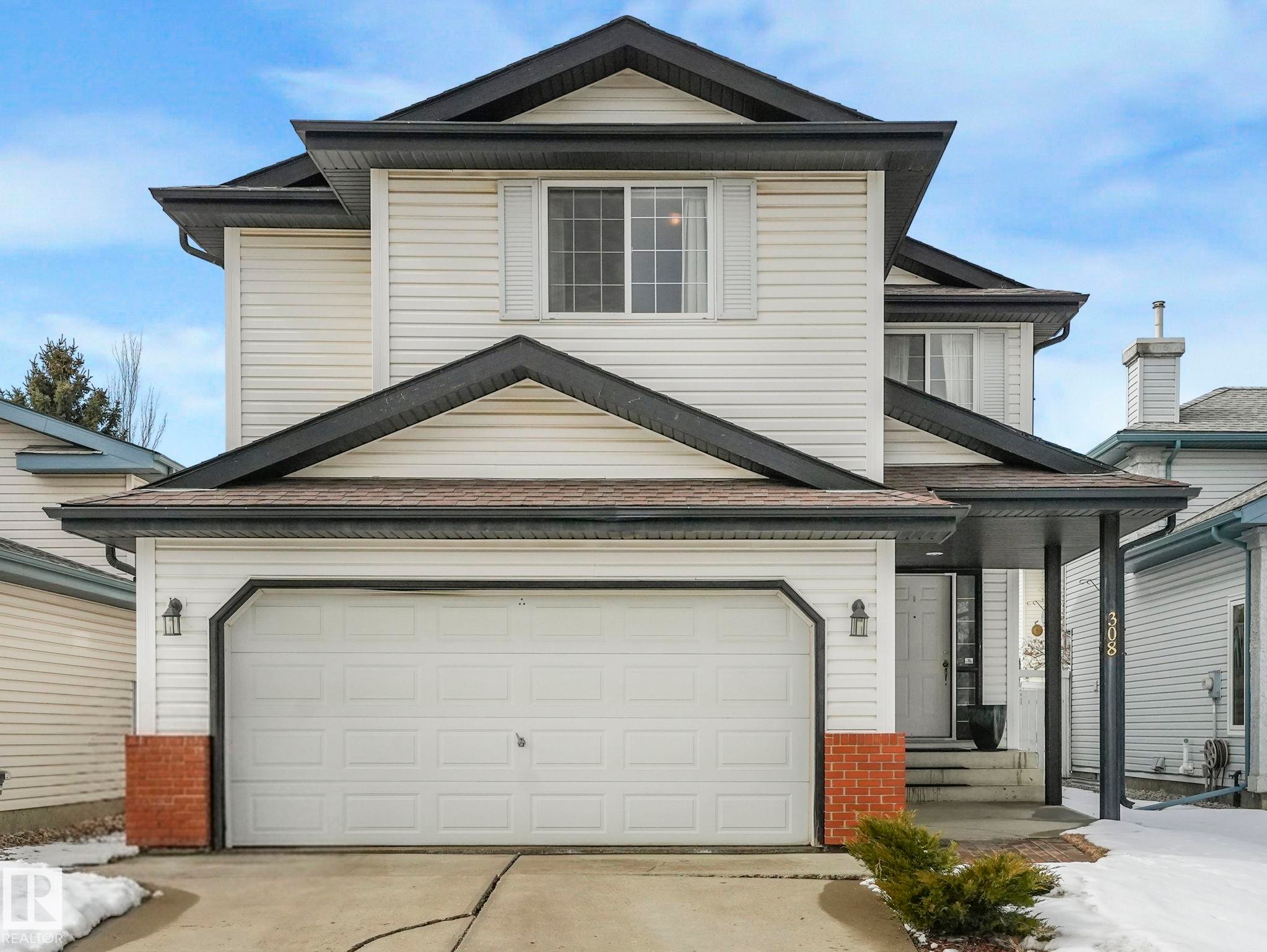 The property features a two-story exterior with light-colored siding and dark trim accents - 308 Beringer Crescent, Edmonton, AB - Outdoor With Exterior