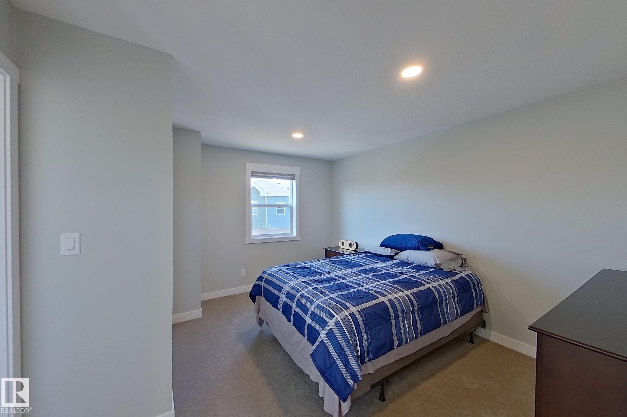 Carpeted room featuring light gray walls, recessed lighting, and a white-trimmed window - 33 150 Everitt Dr, St. Albert, AB - Indoor Photo Showing Bedroom