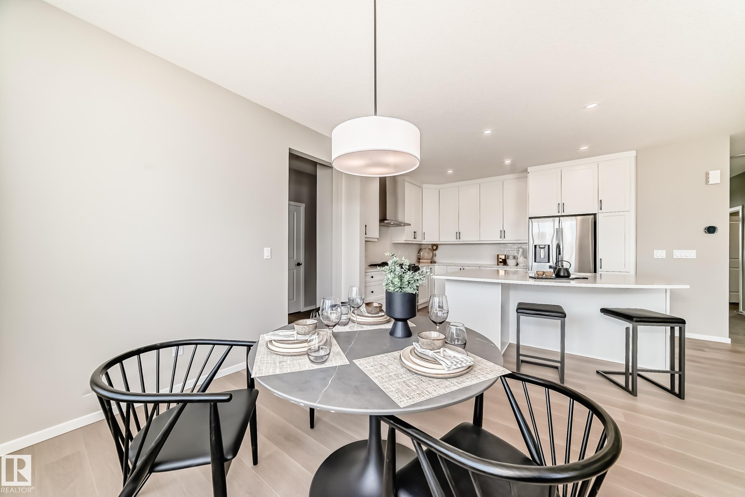 Dining area with light wood-finish flooring and a contemporary pendant light fixture - 1603 206 Street, Edmonton, AB - Indoor