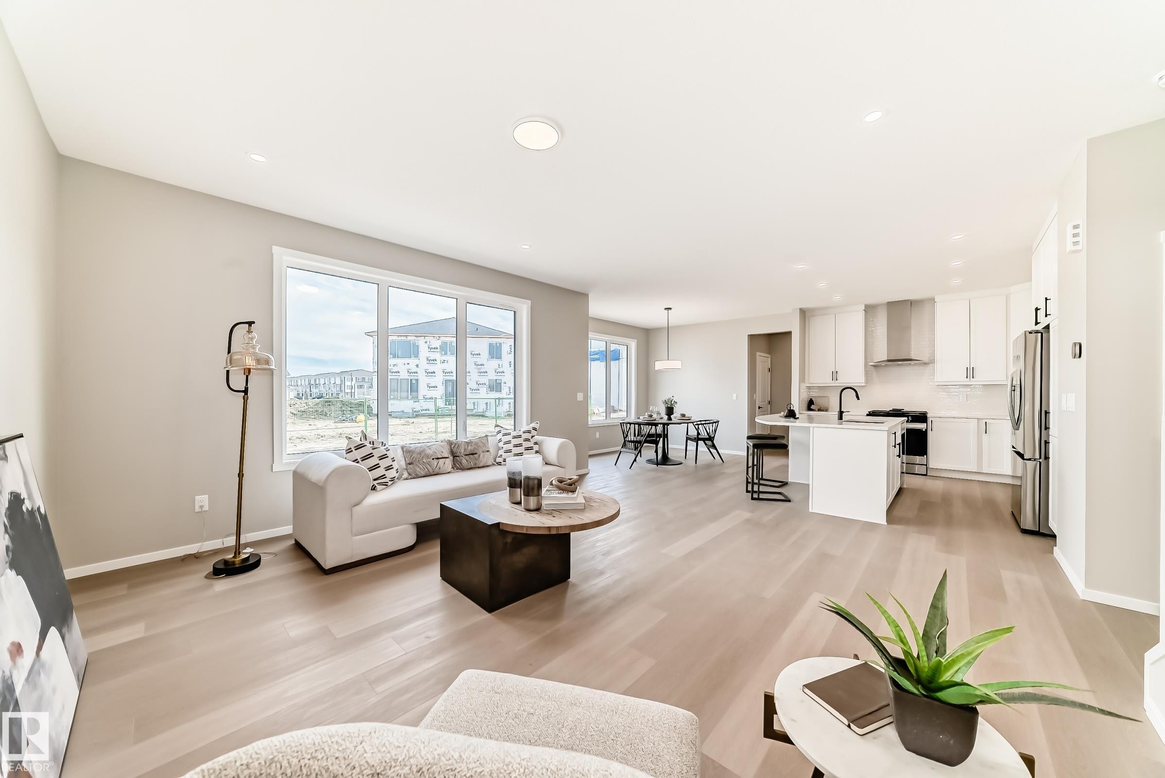 Open-concept living space featuring wood-finish flooring, recessed lighting, and large windows - 1603 206 Street, Edmonton, AB - Indoor Photo Showing Living Room