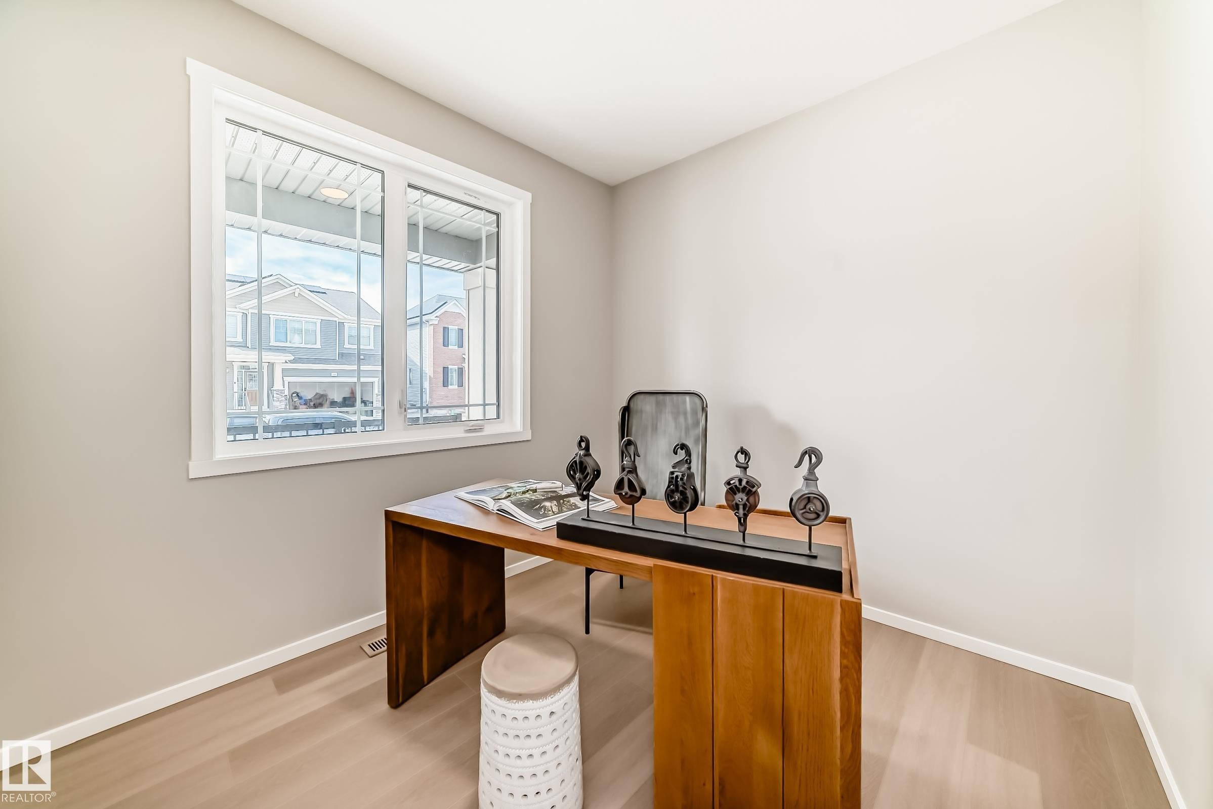 Bright room featuring a large white-framed window, light wood-finish flooring, and neutral wall tones - 1603 206 Street, Edmonton, AB - Indoor Photo Showing Office