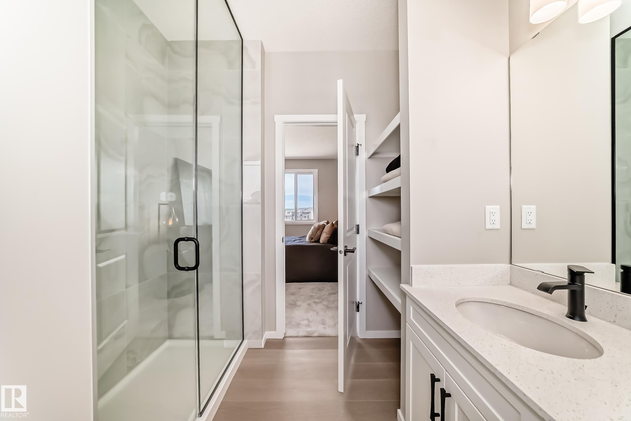 Bathroom featuring a clear glass shower enclosure with matte black hardware, a shower niche, and light-toned wall tile - 1603 206 Street, Edmonton, AB - Indoor Photo Showing Bathroom