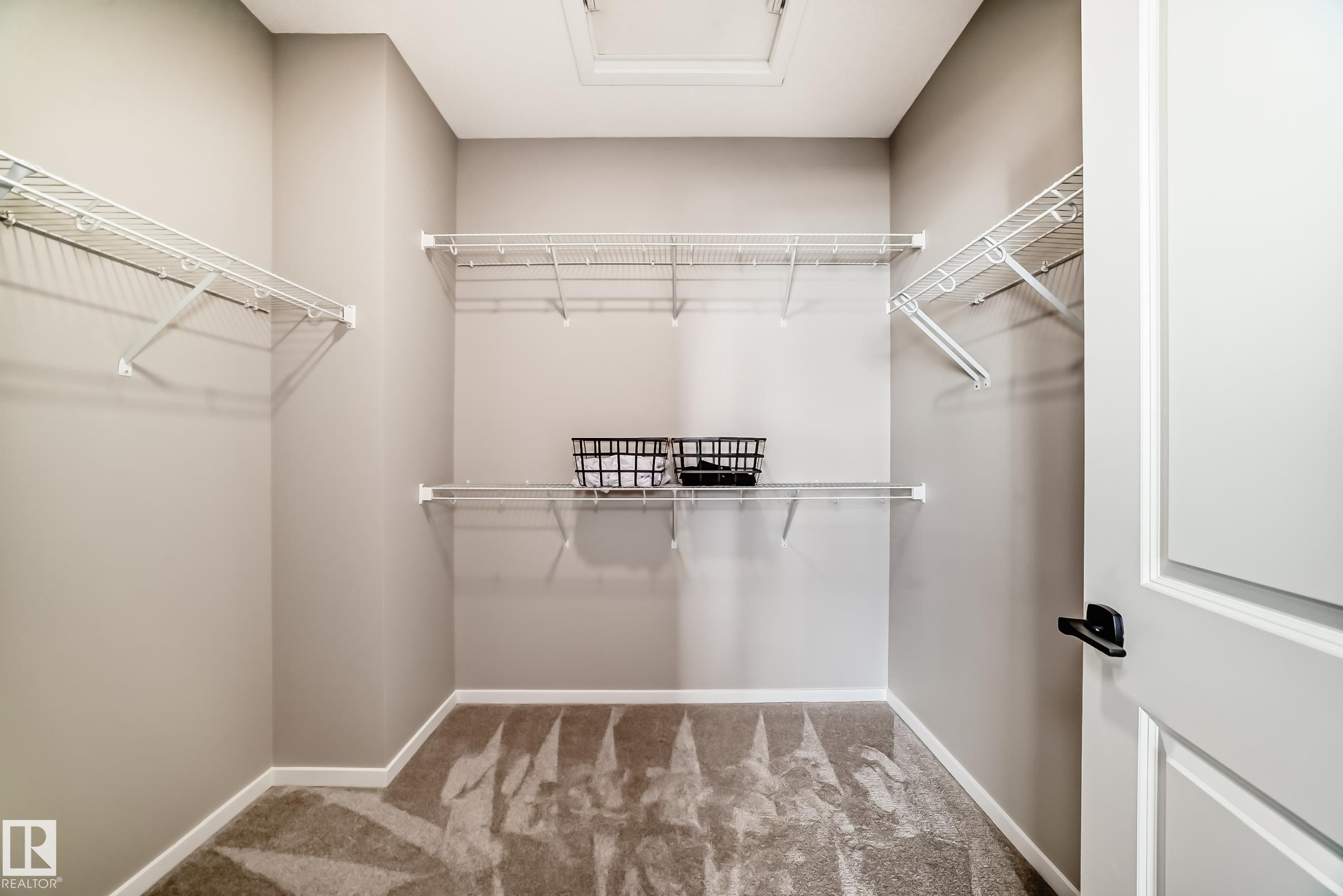 Spacious walk-in closet featuring wire shelving systems, light gray wall paint, and plush carpeting - 1603 206 Street, Edmonton, AB - Indoor With Storage