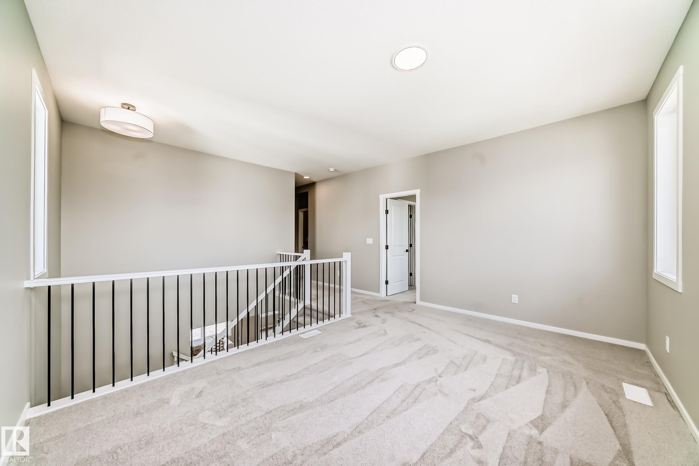 Carpeted landing featuring a white railing with black balusters, recessed lighting, and a drum-style ceiling light - 1603 206 Street, Edmonton, AB - Indoor Photo Showing Other Room