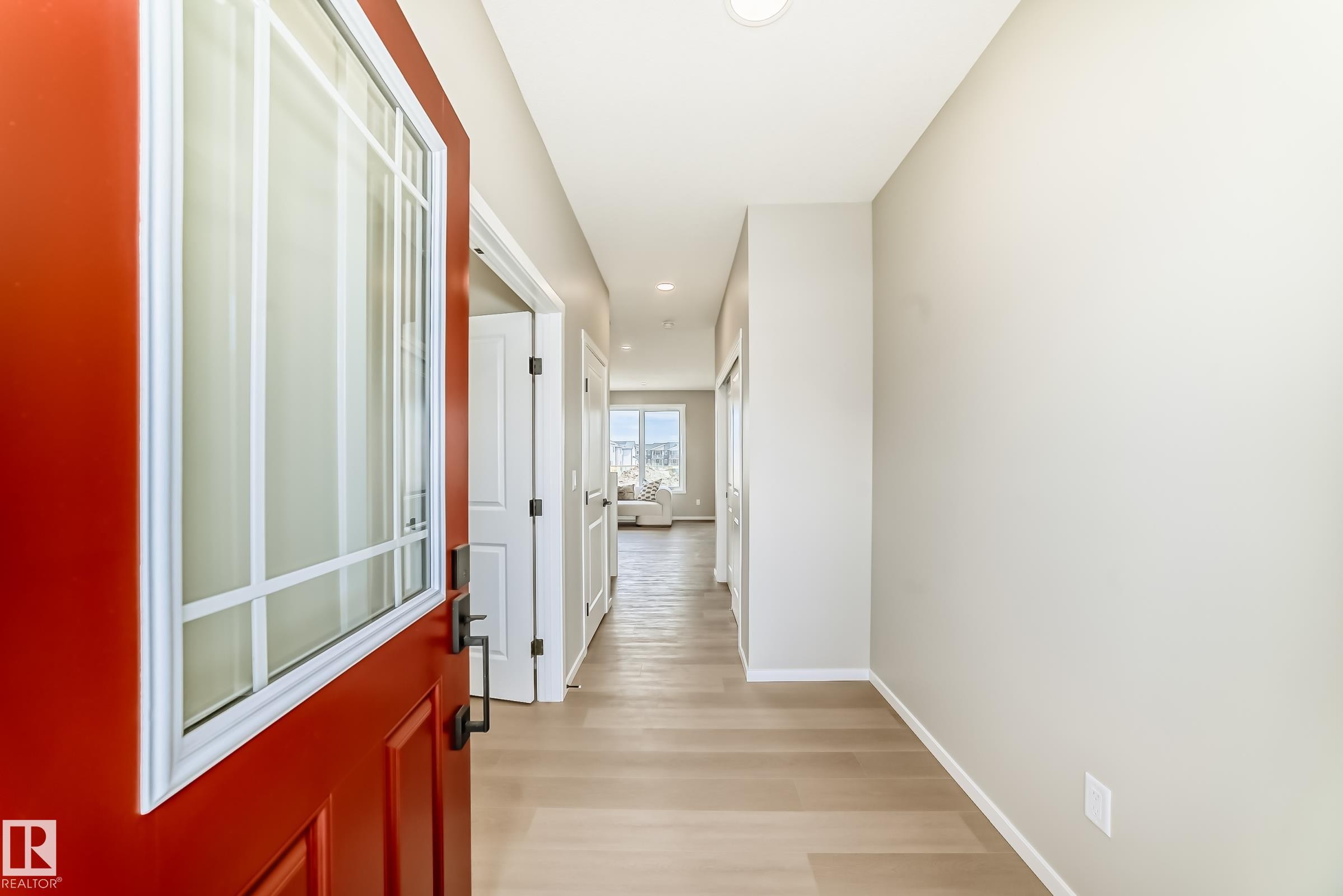 Entryway featuring a red paneled door with decorative glass inserts, recessed lighting, light wood-finish flooring, and neutral wall paint - 1603 206 Street, Edmonton, AB - Indoor Photo Showing Other Room