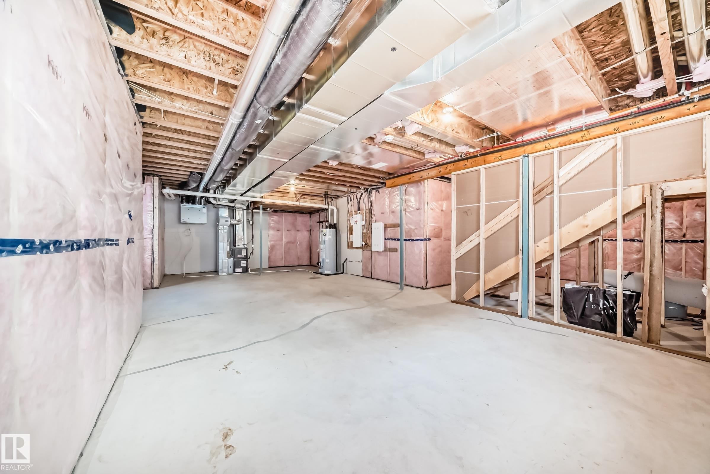 Unfinished basement featuring exposed wood joists, concrete flooring, framed wall sections, and insulation - 1603 206 Street, Edmonton, AB - Indoor