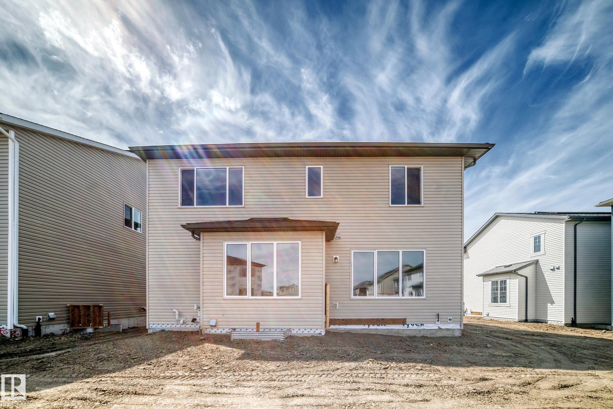 Two-story property featuring horizontal siding and multiple windows on the rear facade - 1603 206 Street, Edmonton, AB - Outdoor With Exterior