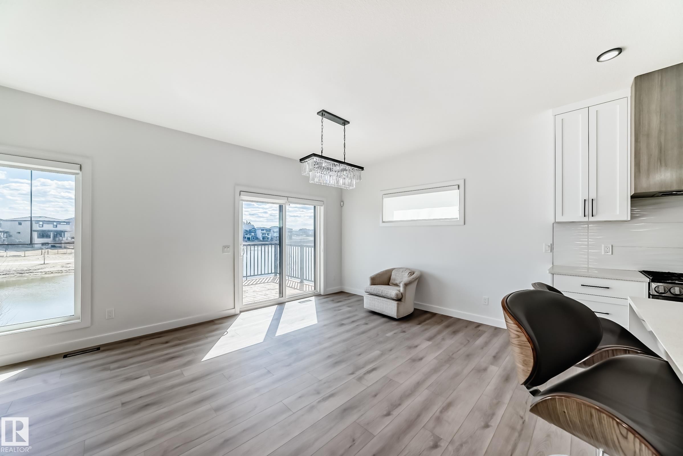 Open-concept living area featuring wood-finish flooring and ample natural light - 3247 Chernowski Way, Edmonton, AB - Indoor