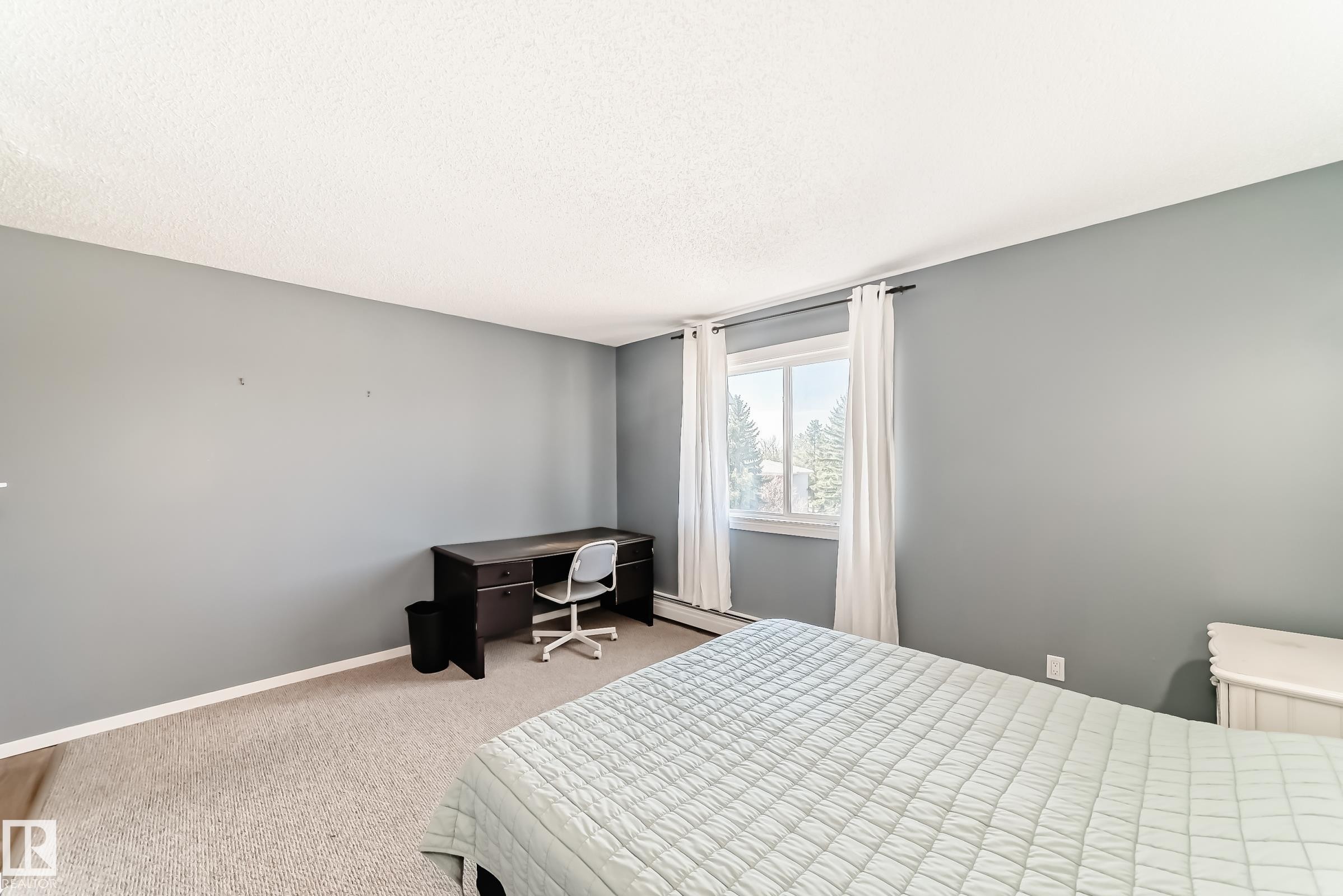 Carpeted room with light gray walls and white trim - 423 5125 Riverbend Road, Edmonton, AB - Indoor Photo Showing Bedroom