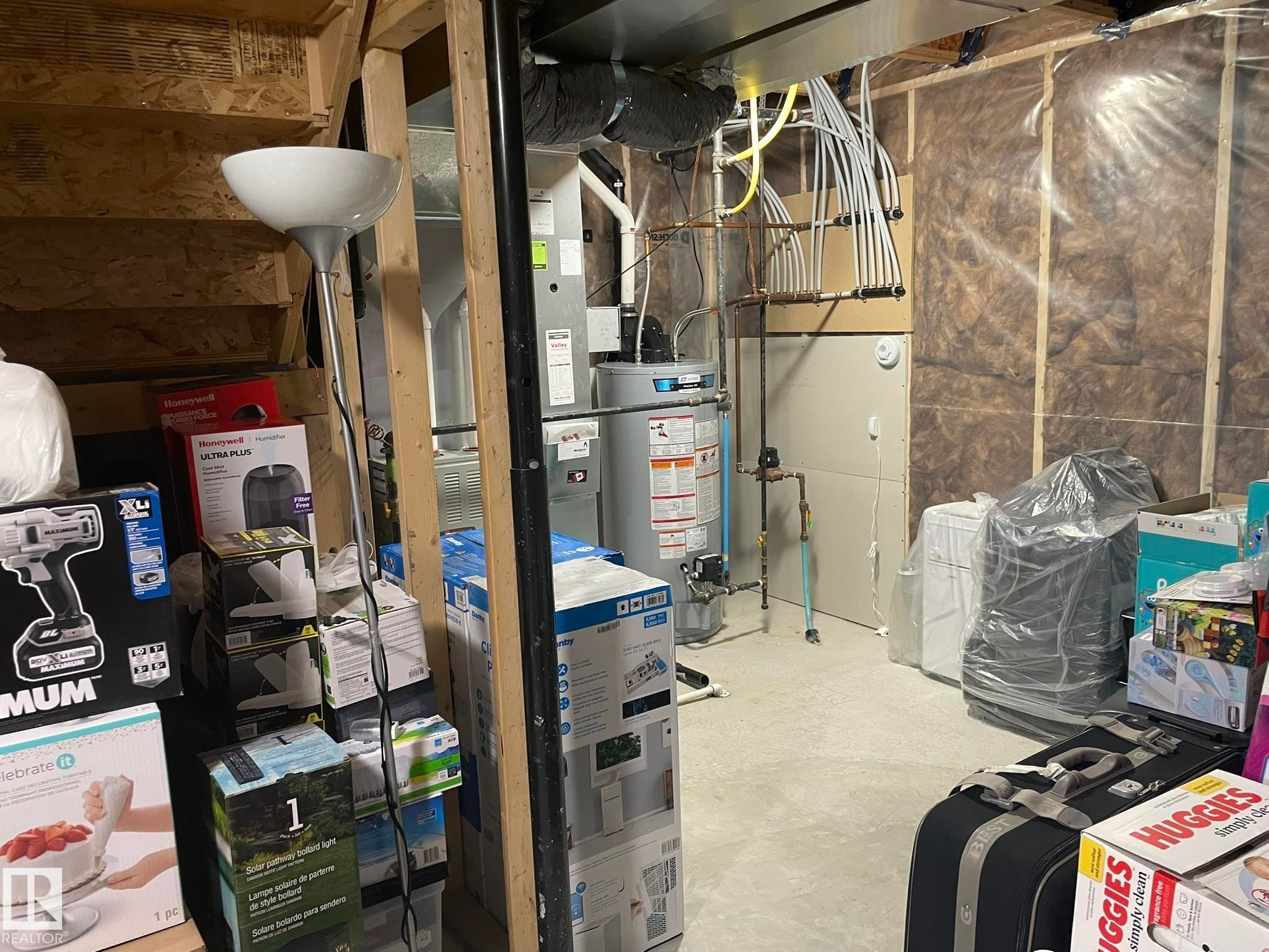 Utility area featuring a water heater, furnace, and exposed insulation - 871 Ebbers Crescent, Edmonton, AB - Indoor Photo Showing Basement