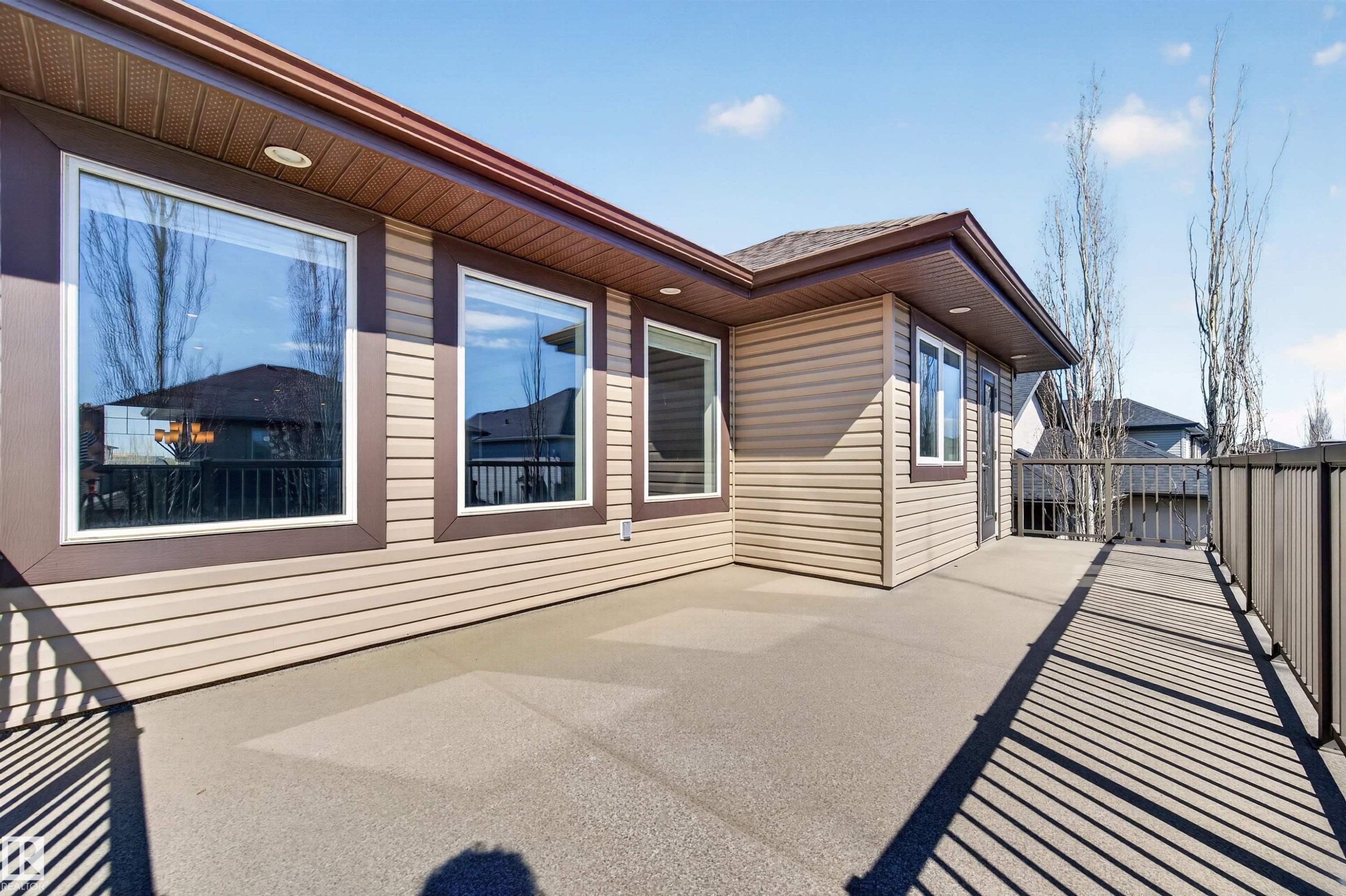 Spacious outdoor deck with textured concrete flooring and dark metal railings - 1254 Adamson Drive, Edmonton, AB - Outdoor