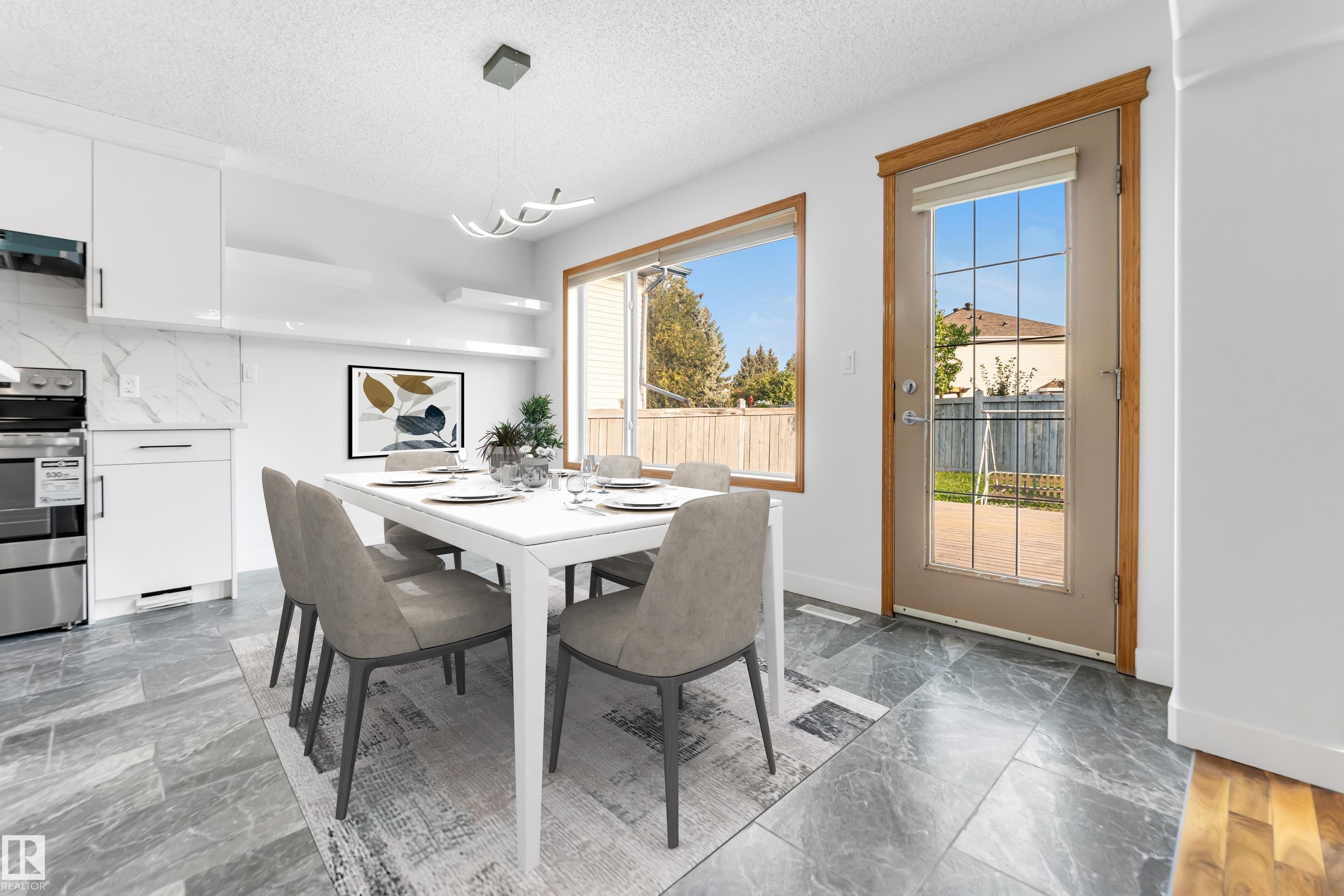 Dining area with large format tile flooring, white cabinetry, integrated shelving, and a glass-paneled exterior door - 10621 175A Avenue, Edmonton, AB