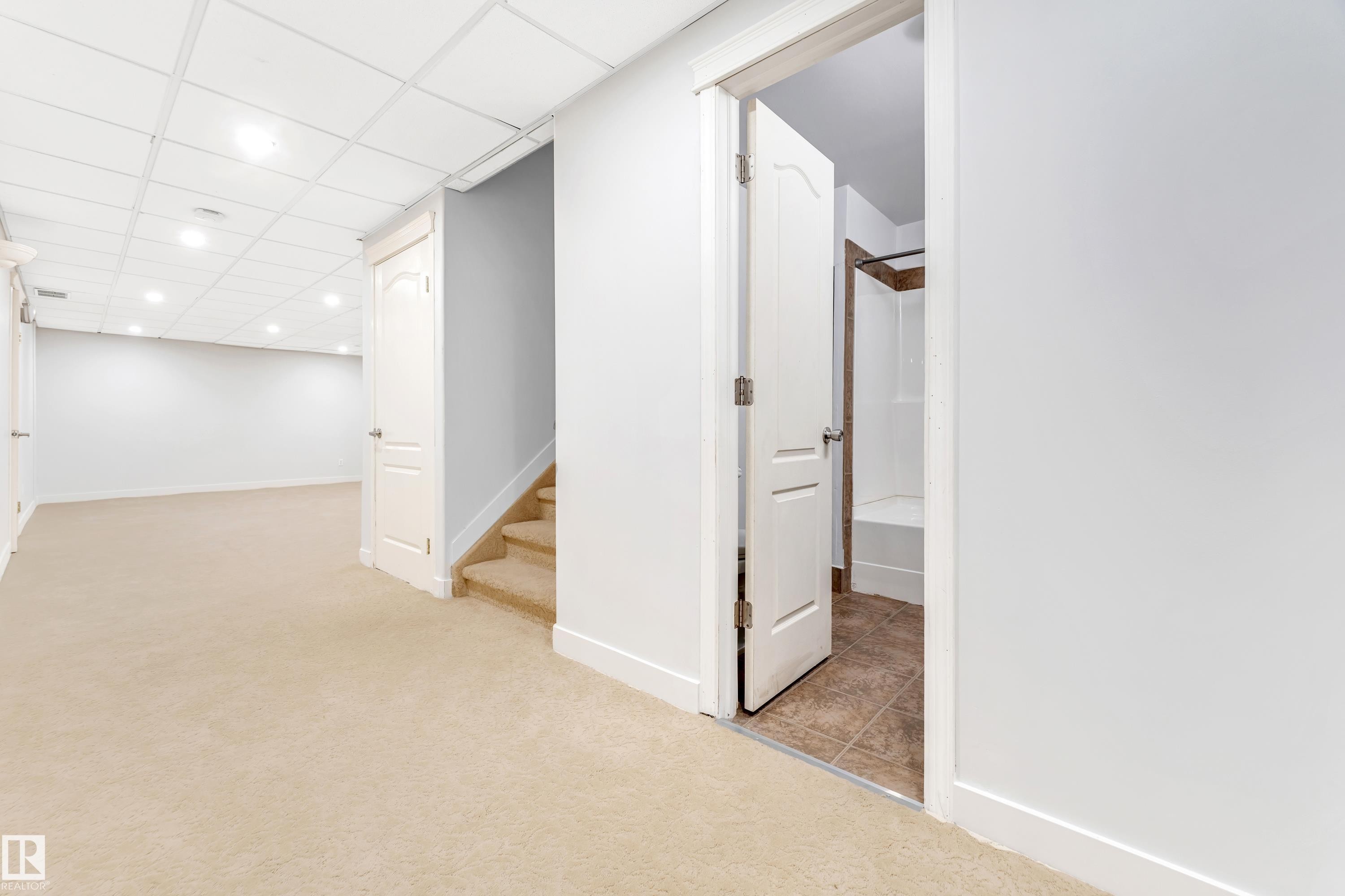 Spacious finished basement featuring recessed lighting, a drop ceiling, and plush neutral carpeting - 10621 175A Avenue, Edmonton, AB