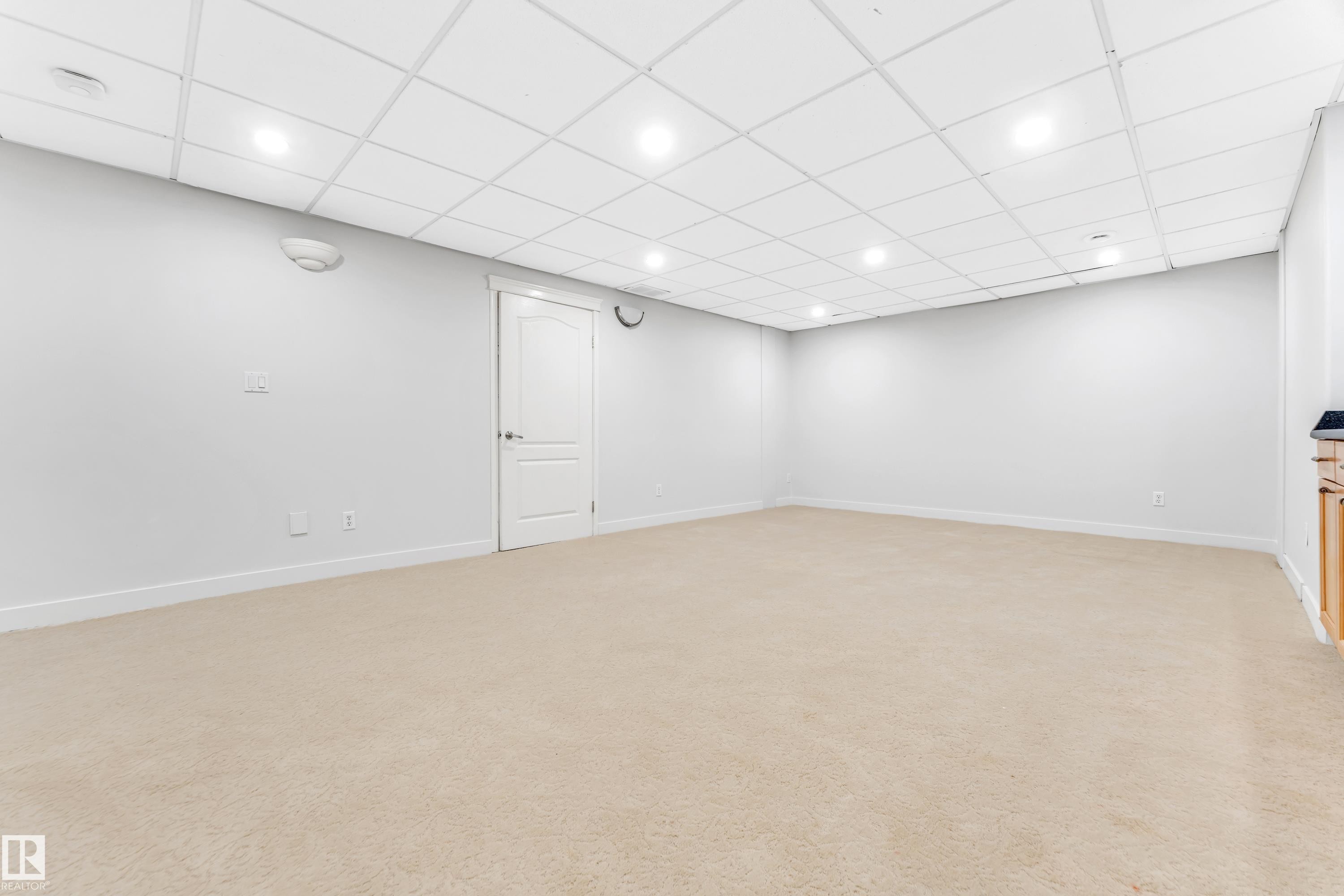 Spacious room featuring neutral carpeting, recessed lighting, and a drop ceiling - 10621 175A Avenue, Edmonton, AB