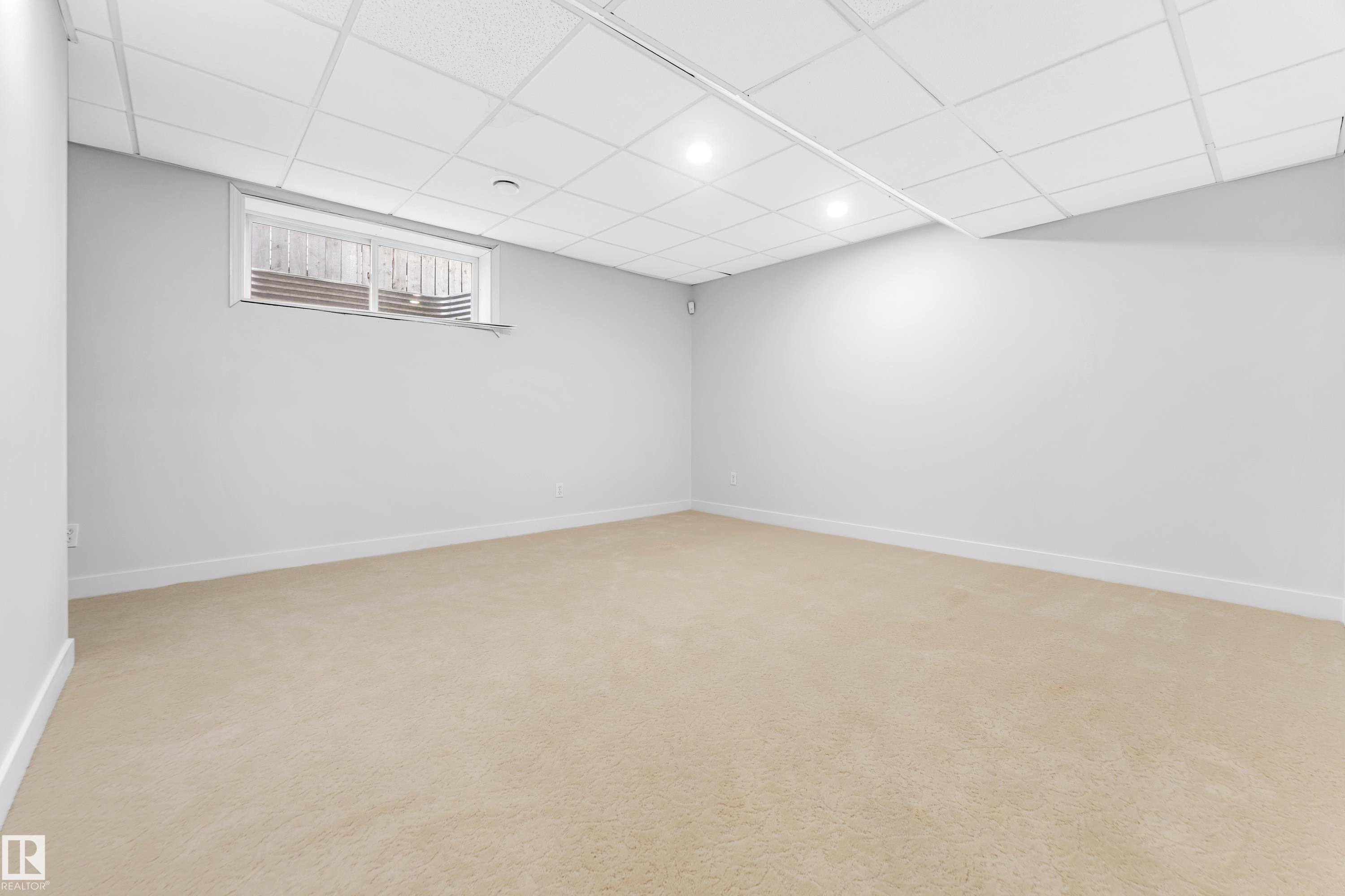 Finished room featuring light beige carpeting, white walls, and a drop ceiling with recessed lighting - 10621 175A Avenue, Edmonton, AB
