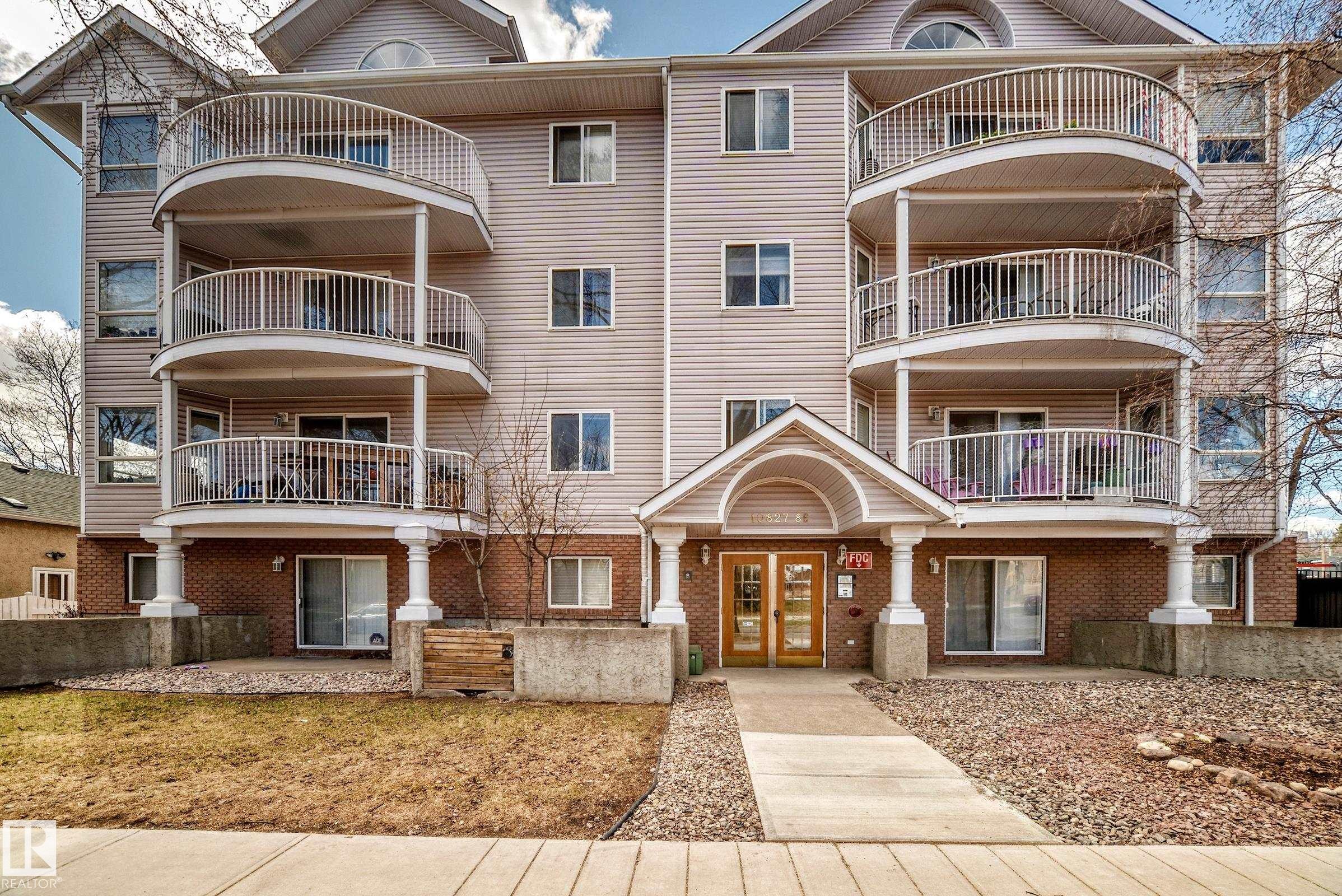 Multi-story residential building featuring light-colored siding and brick accents - 101 10827 85 Avenue Nw, Edmonton, AB - Outdoor With Facade