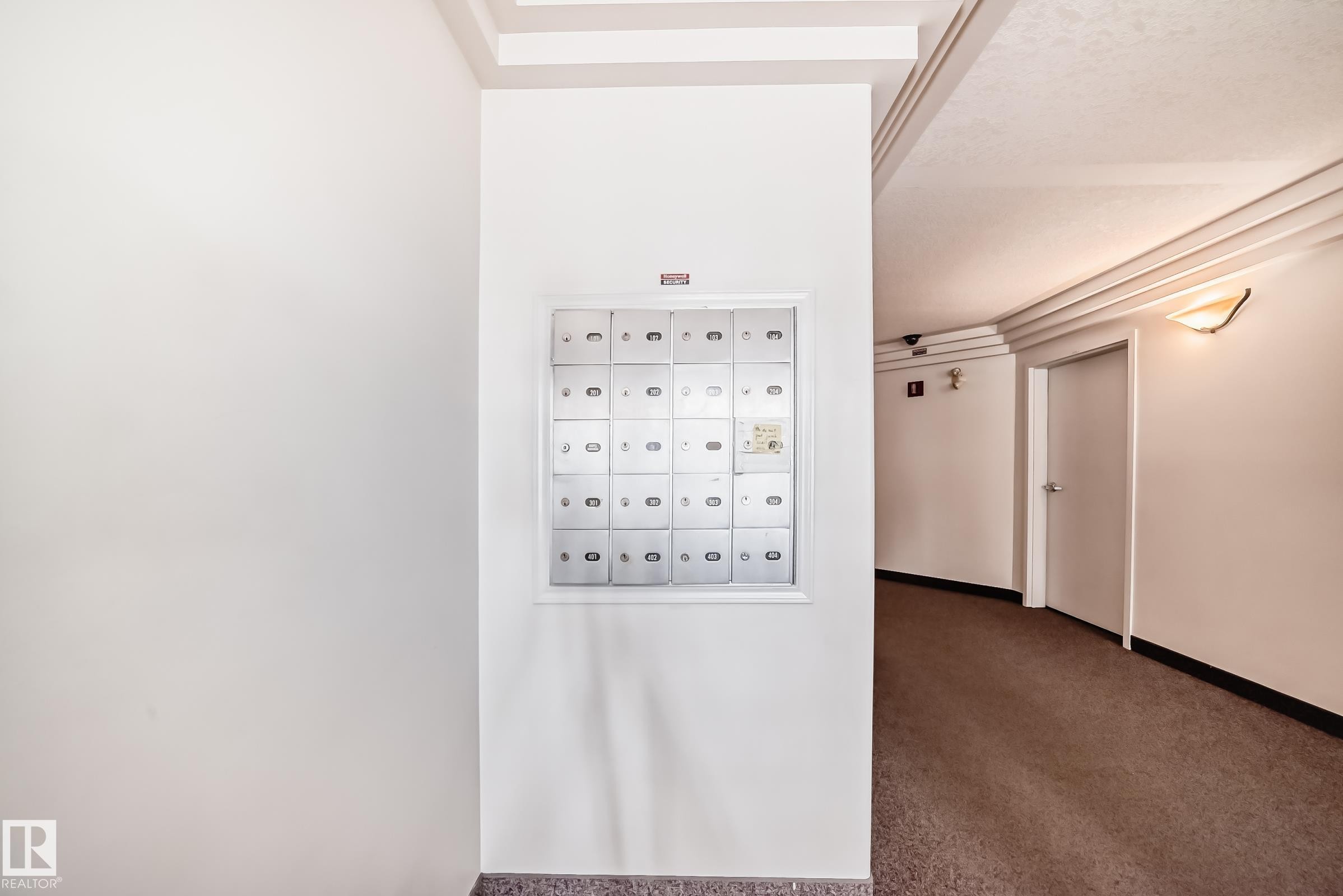 Wall-mounted mailboxes within a common area corridor featuring recessed lighting, a textured ceiling, and a wall sconce - 101 10827 85 Avenue Nw, Edmonton, AB - Indoor Photo Showing Other Room