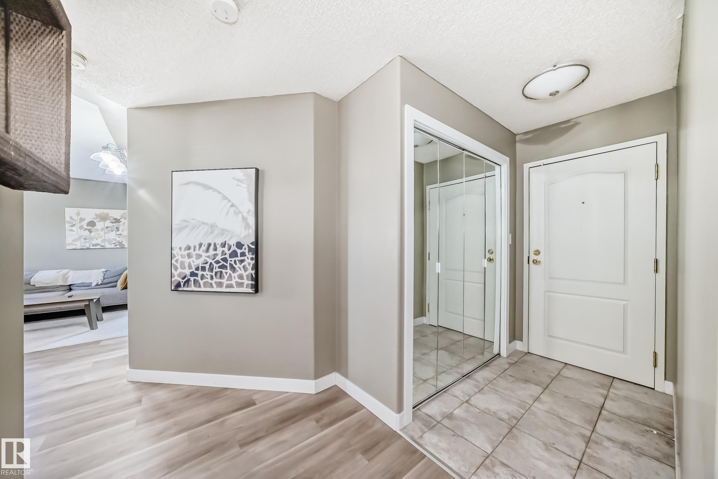 Entryway featuring neutral wall paint, wood-finish flooring, and a tiled landing - 101 10827 85 Avenue Nw, Edmonton, AB - Indoor Photo Showing Other Room