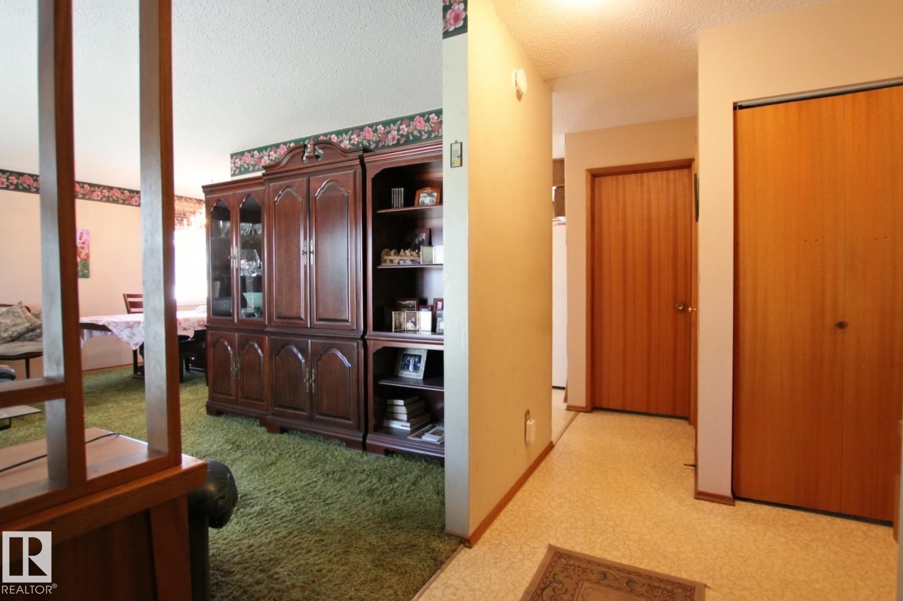 Hallway featuring light-colored walls and wood-finish doors - 3539 104 Street, Edmonton, AB - Indoor Photo Showing Other Room