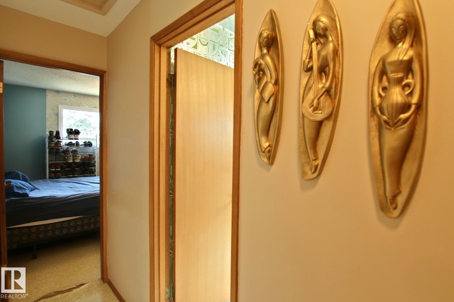 Hallway with light-colored walls and wood-trimmed doorways - 3539 104 Street, Edmonton, AB - Indoor