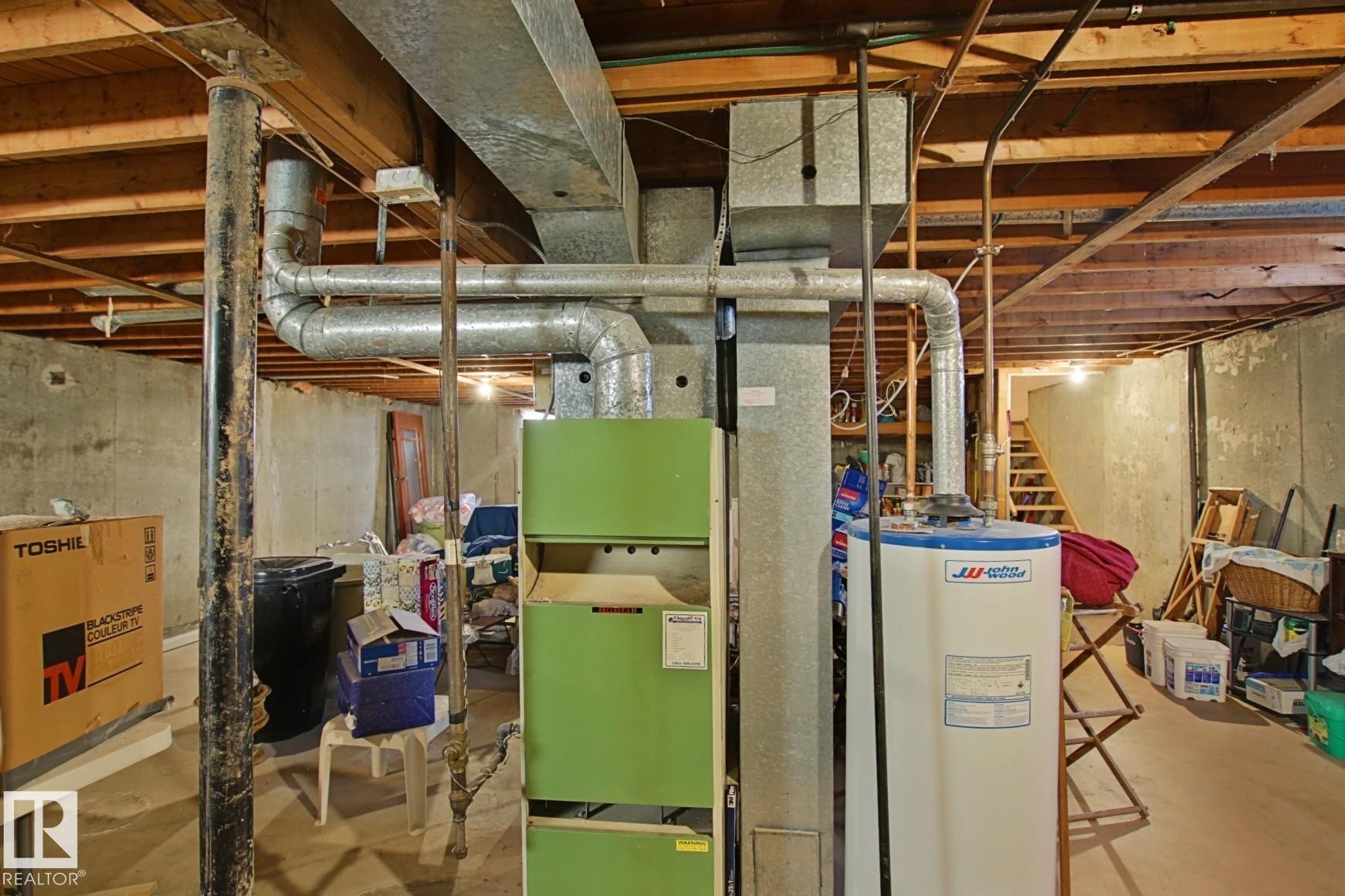 Utility area featuring a furnace system, water heater, exposed ductwork, and open wood joist ceiling - 3539 104 Street, Edmonton, AB - Indoor Photo Showing Basement