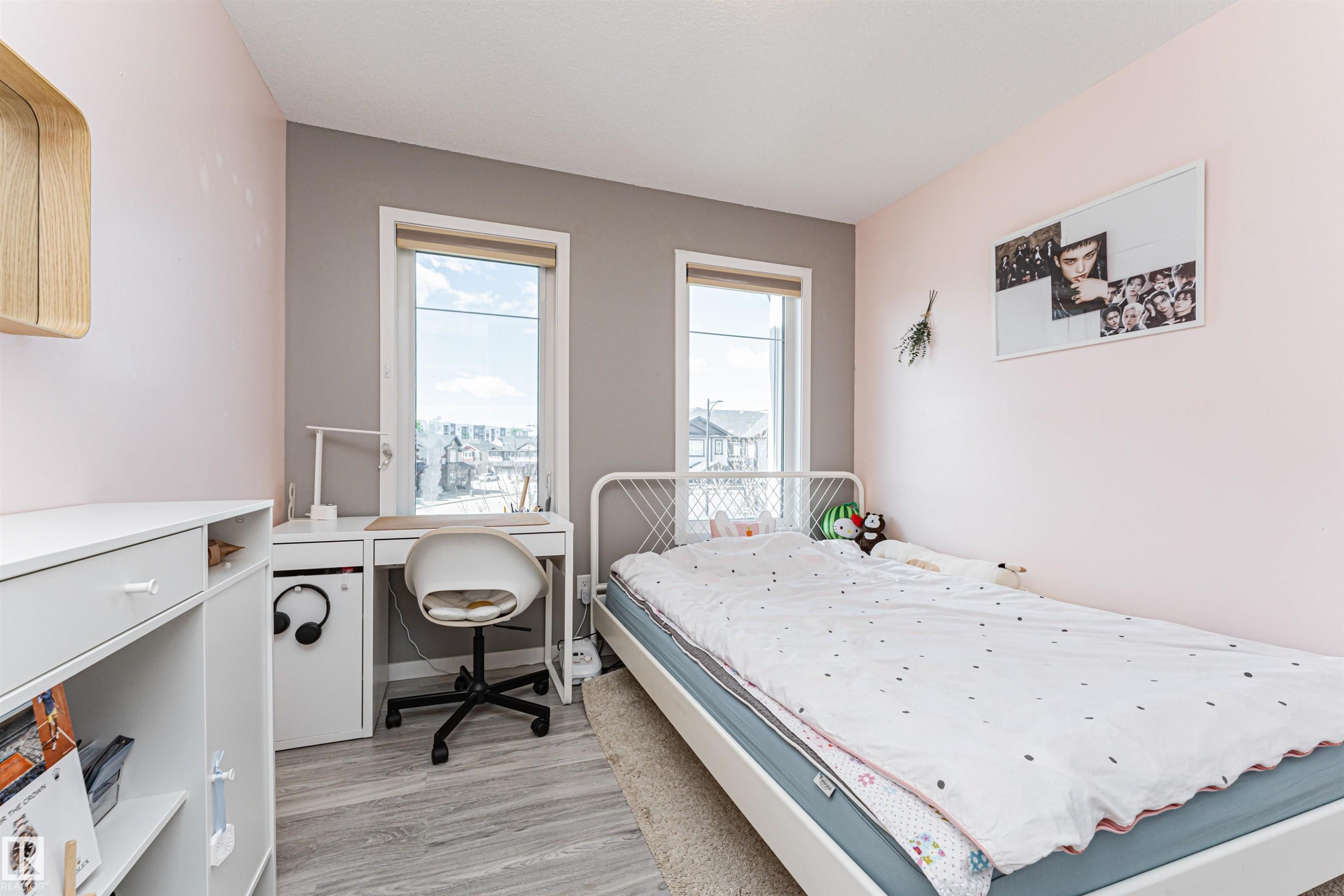 Room featuring two vertical windows, wood-finish flooring, and a color-block wall design - 4452 Annett Common, Edmonton, AB