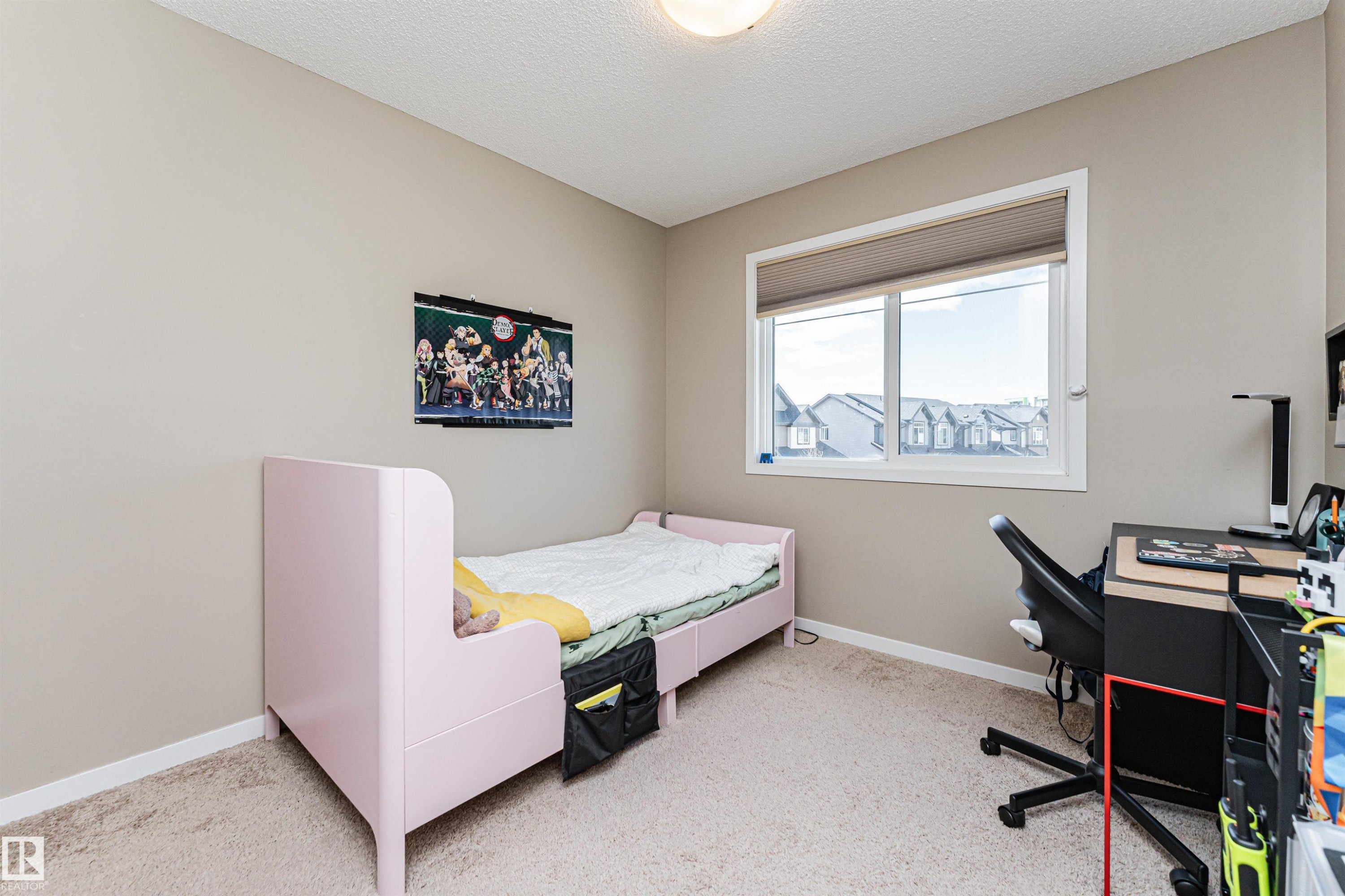 Carpeted room with a large window, neutral wall paint, and a ceiling-mounted light fixture - 4452 Annett Common, Edmonton, AB